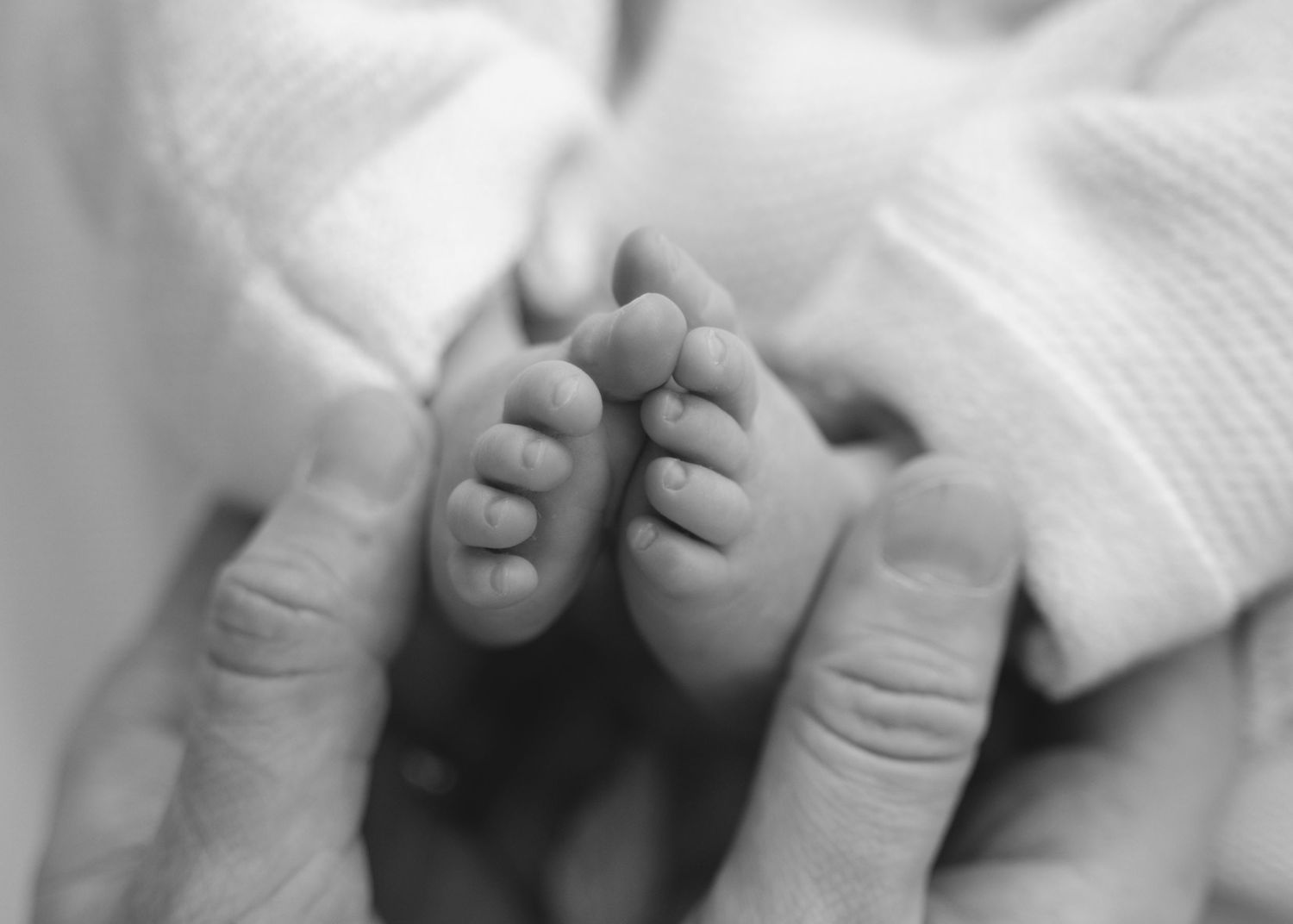 Black and white close-up of a newborn’s feet.