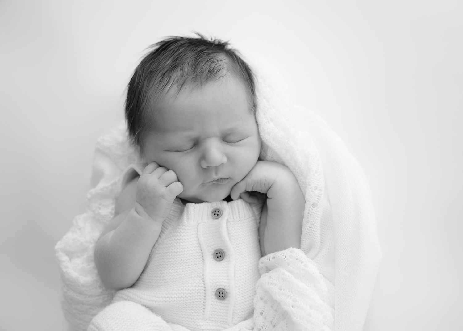 Close-up of newborn baby’s toes held by a parent’s hands.