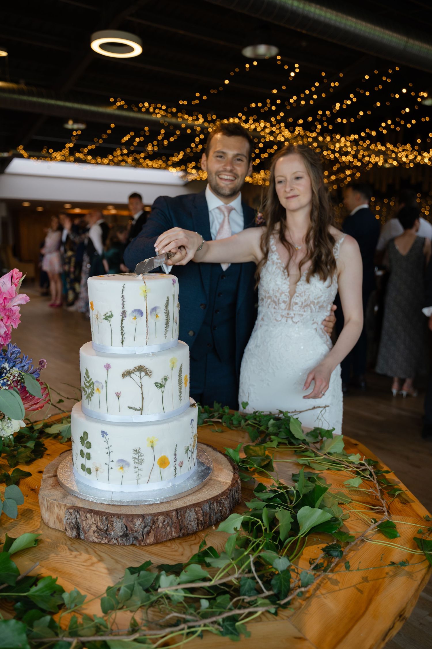 Bride and groom cutting wedding cake at evening reception