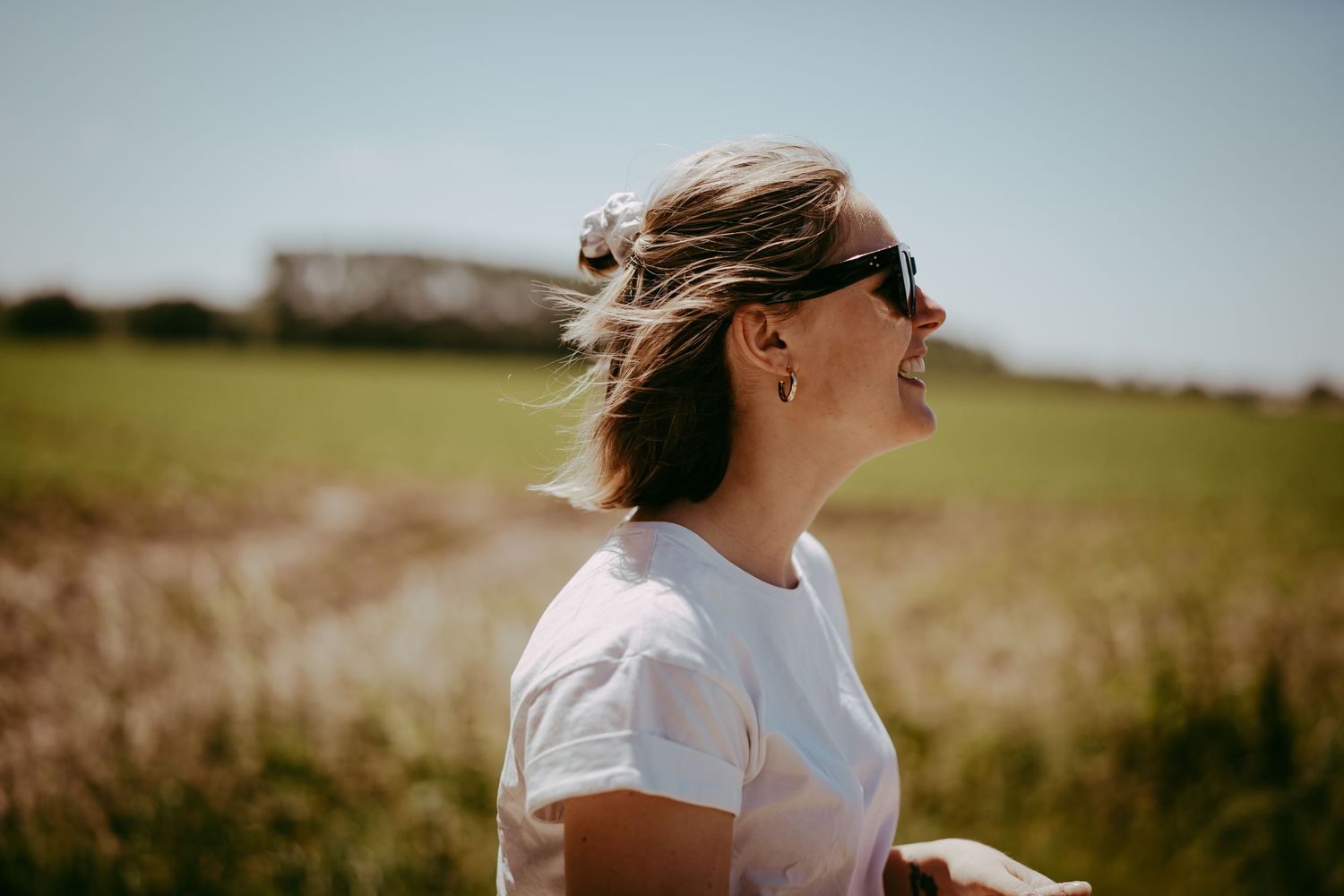 Portret foto van een jonge vrouw in een wei.