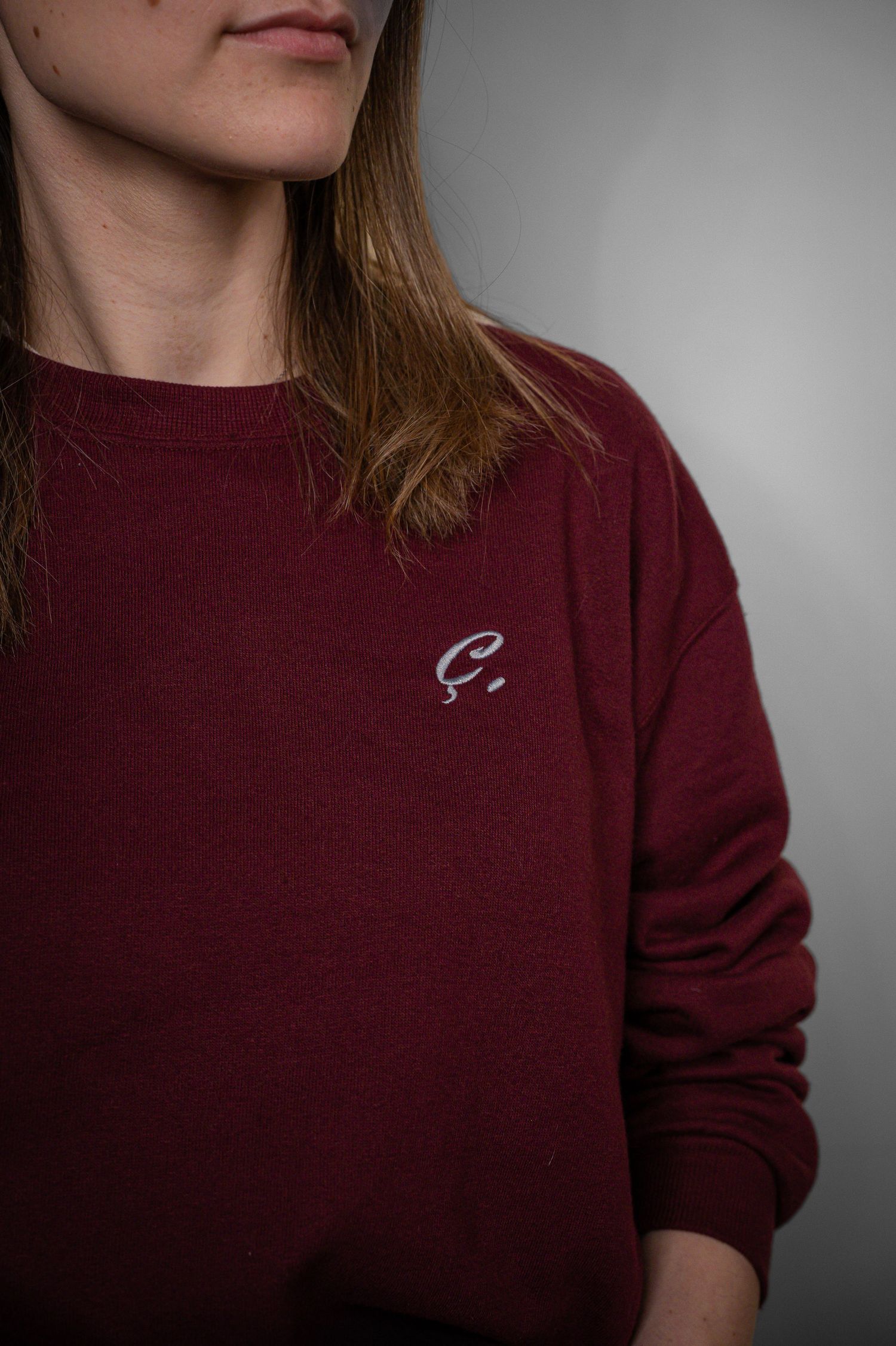 Close-up van het logo van Francois Clothing op een sweater, gedragen door een vrouw.