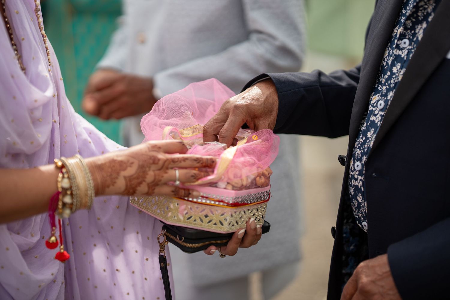 A close-up view of hands exchanging wedding rings during a traditional ceremony.