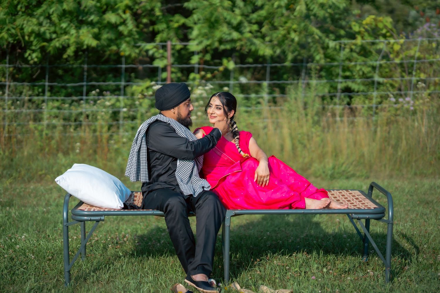 A couple in formal attire shares romantic moments on park benches in a garden setting.