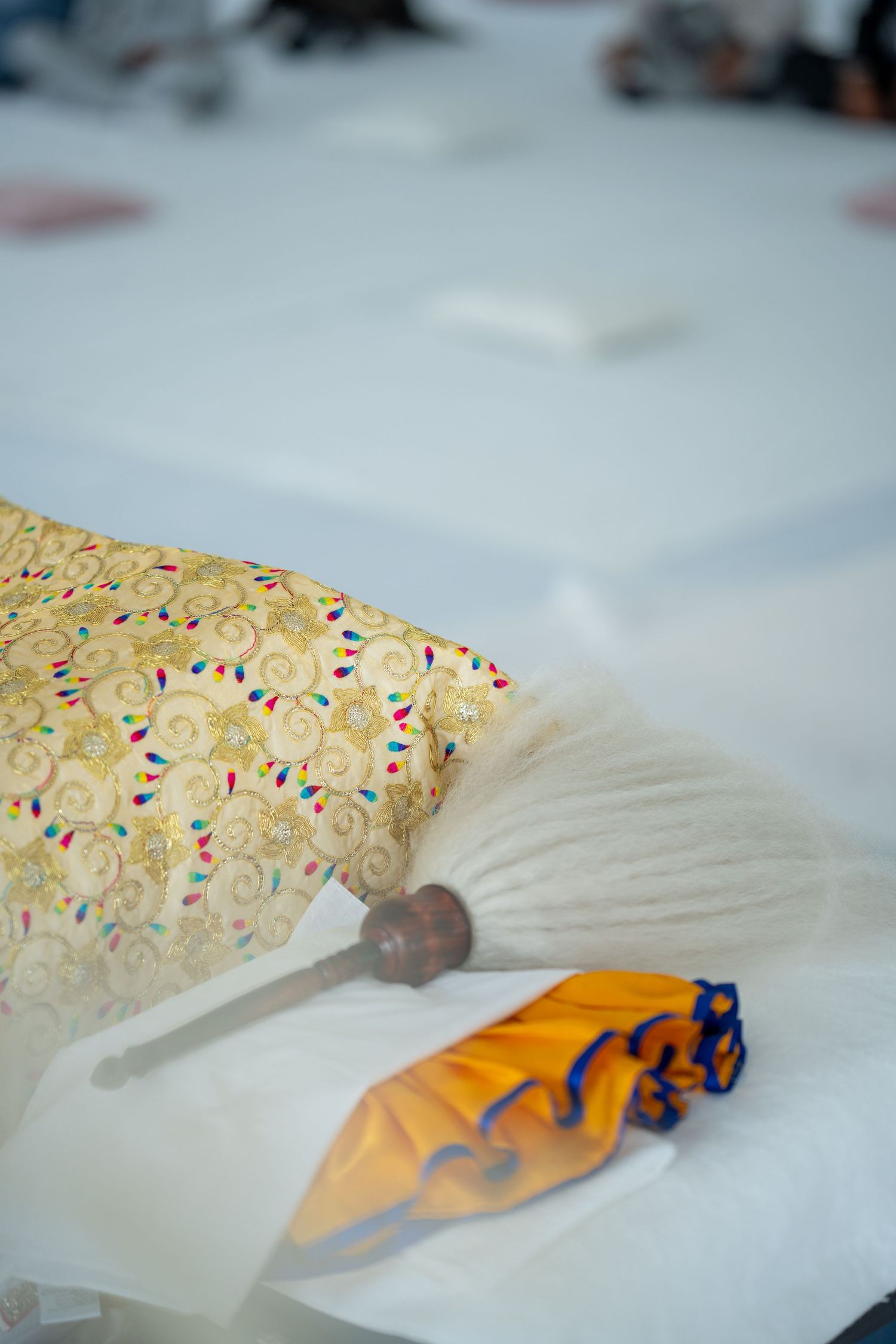 Close-up details of colorful wedding decorations and fabrics on a white surface.