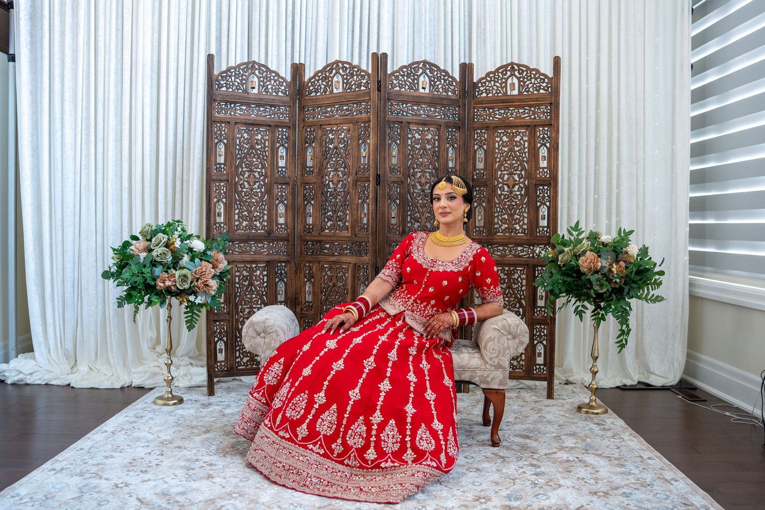 A traditional Sikh wedding ceremony with guests seated in a white-draped venue with ornate decor.