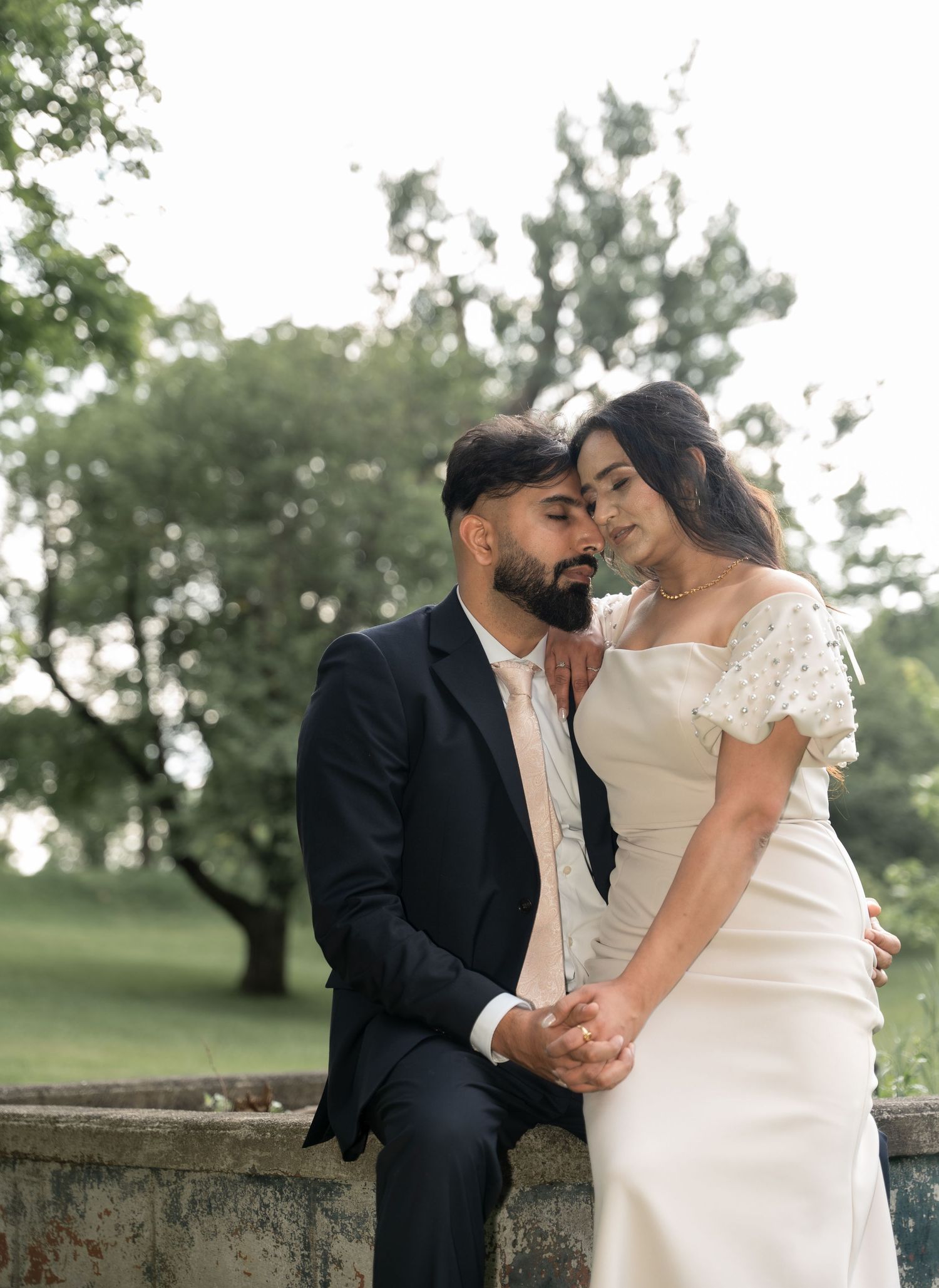 A romantic outdoor wedding photoshoot featuring a couple sharing tender moments against a natural backdrop.