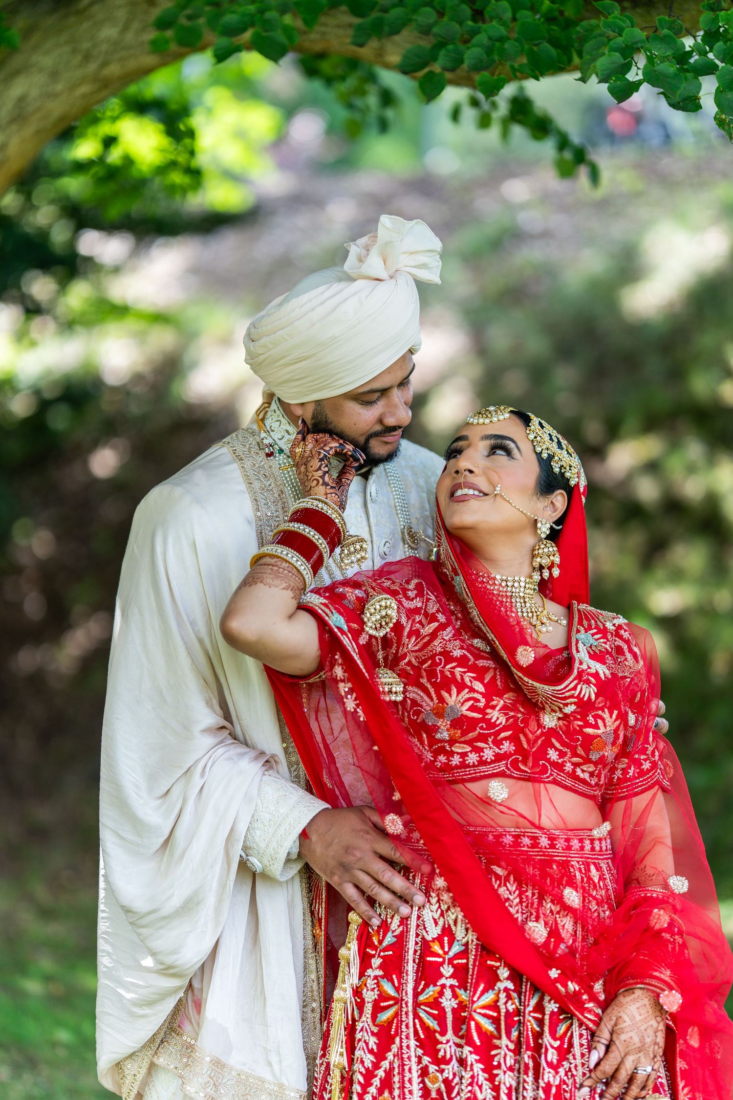 A couple in traditional Indian wedding attire share intimate moments outdoors in a series of romantic photos.