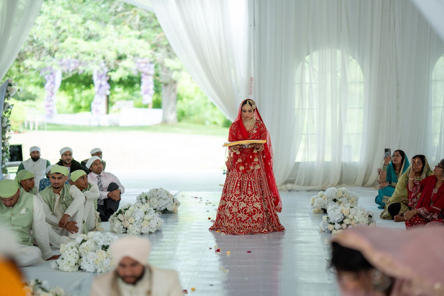 Spacious white wedding tent setup with elegant draping and natural lighting filtering through.