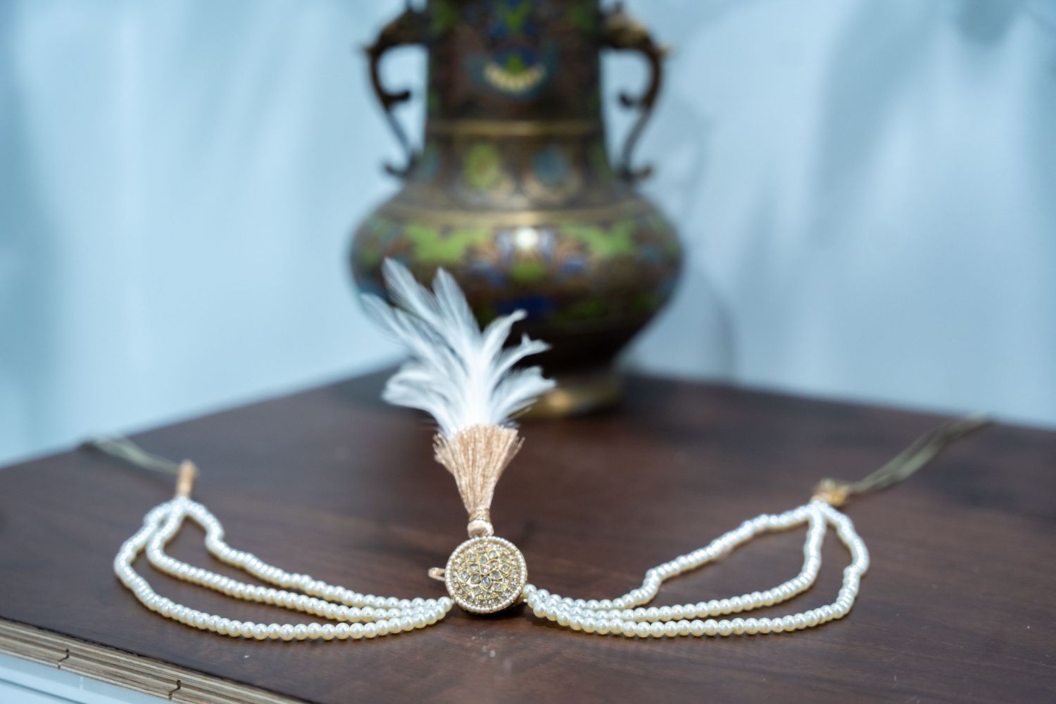 A collection of antique pearl necklaces and jewelry pieces displayed on a dark wooden surface.