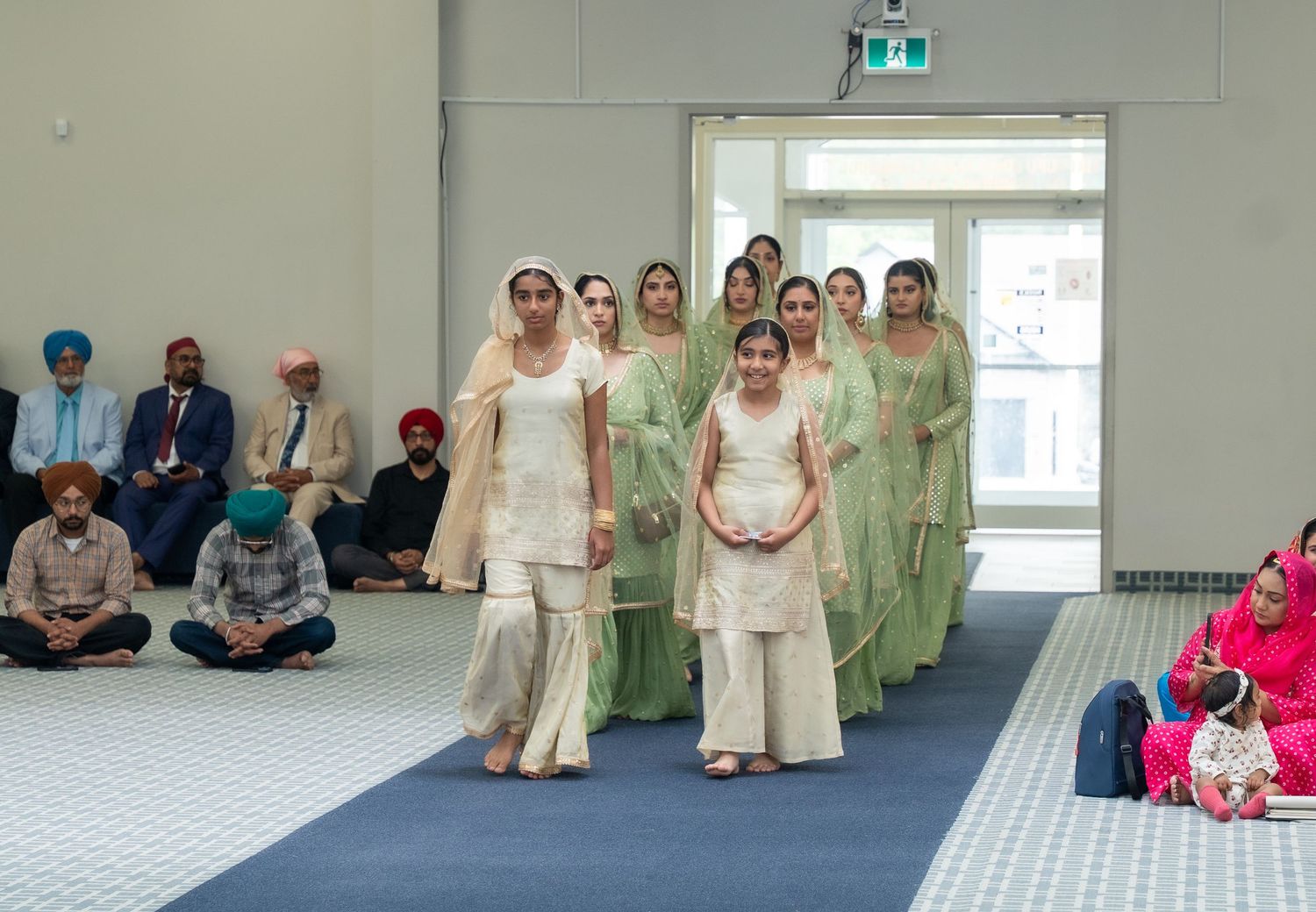 A sequence of meditation or yoga class participants sitting in a bright studio with white walls and large windows.