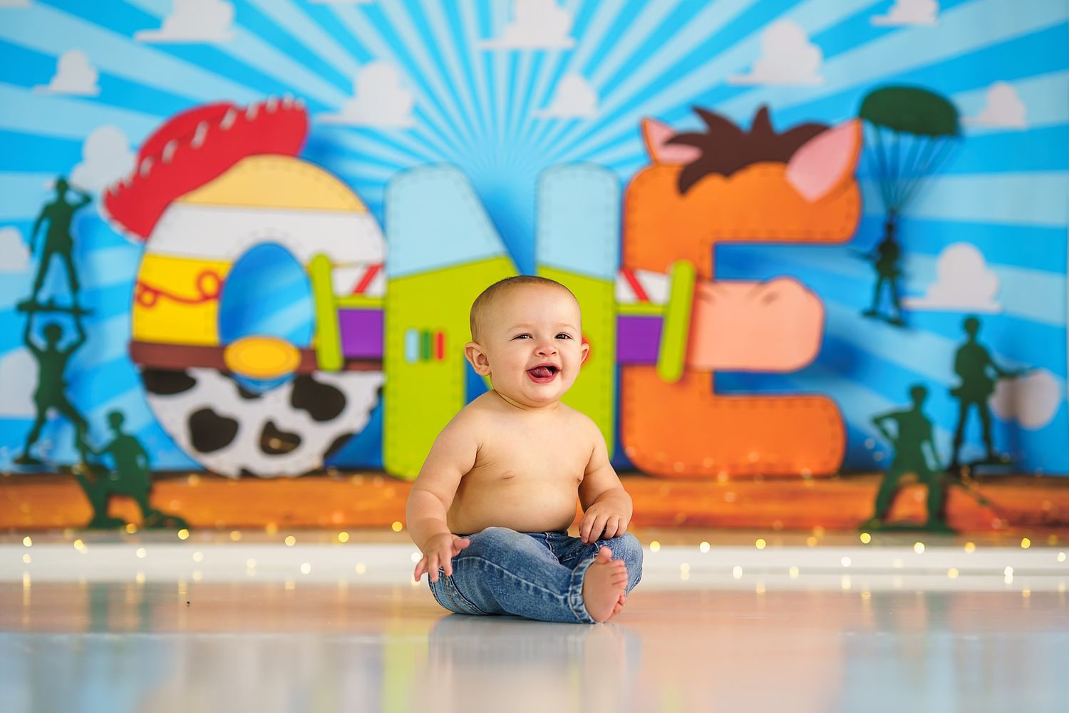Happy infant plays on floor with vibrant pirate-themed party decorations behind them.