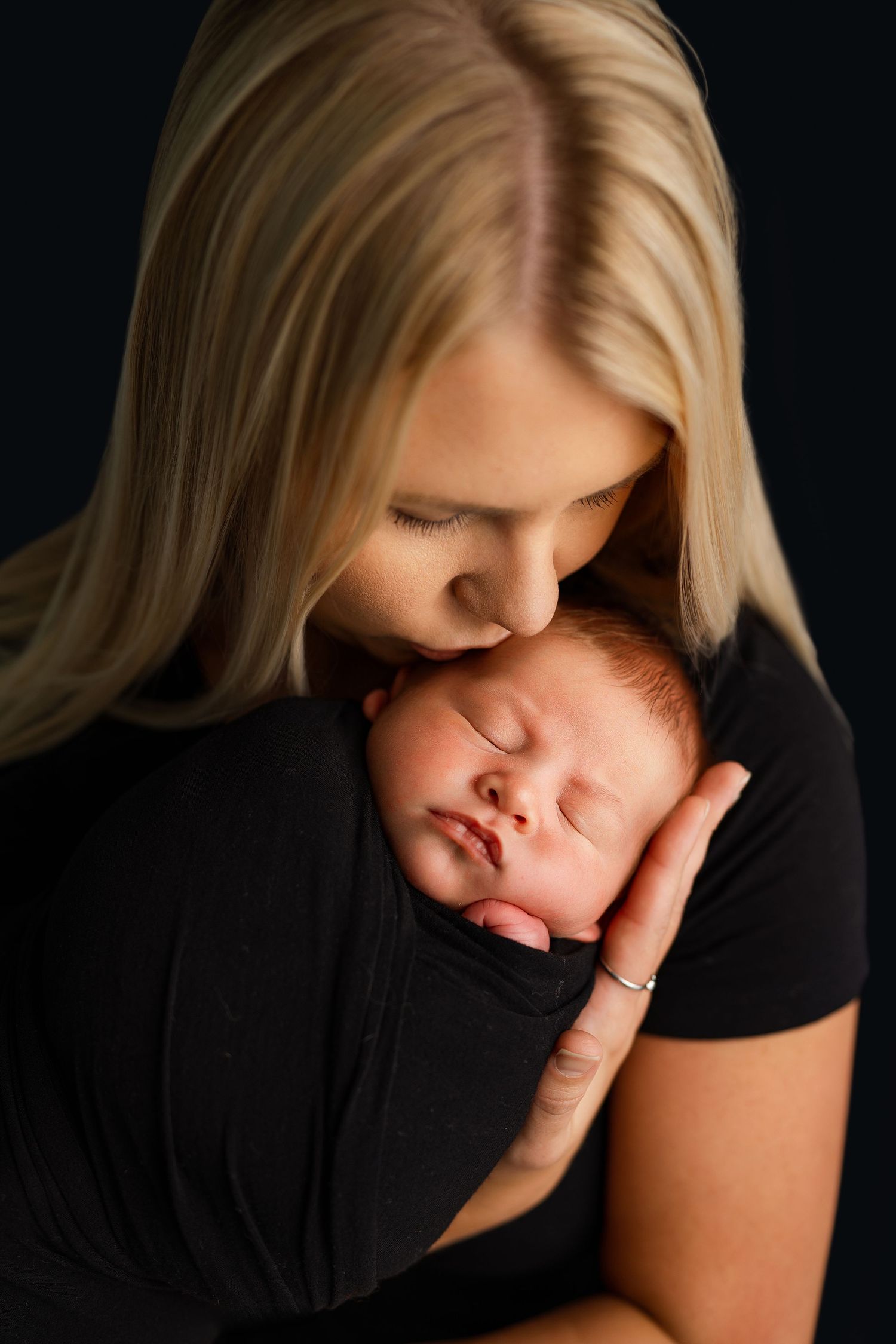 Intimate black and white portrait of tender newborn photography moment.