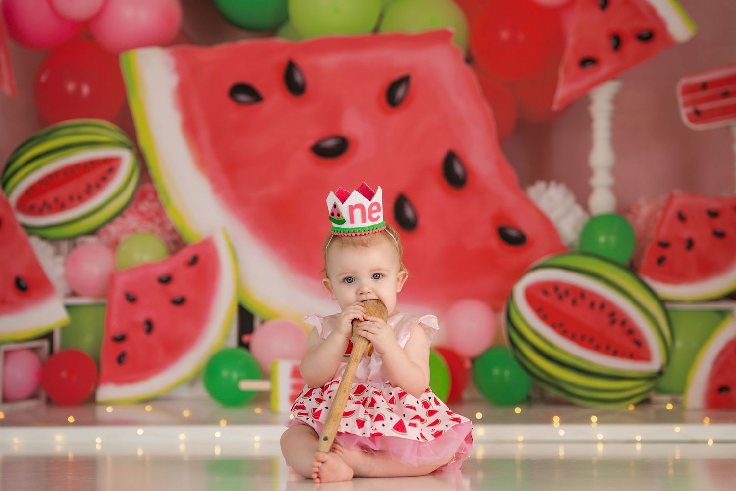 Festive watermelon-patterned background with bright red and green colors and twinkling lights.