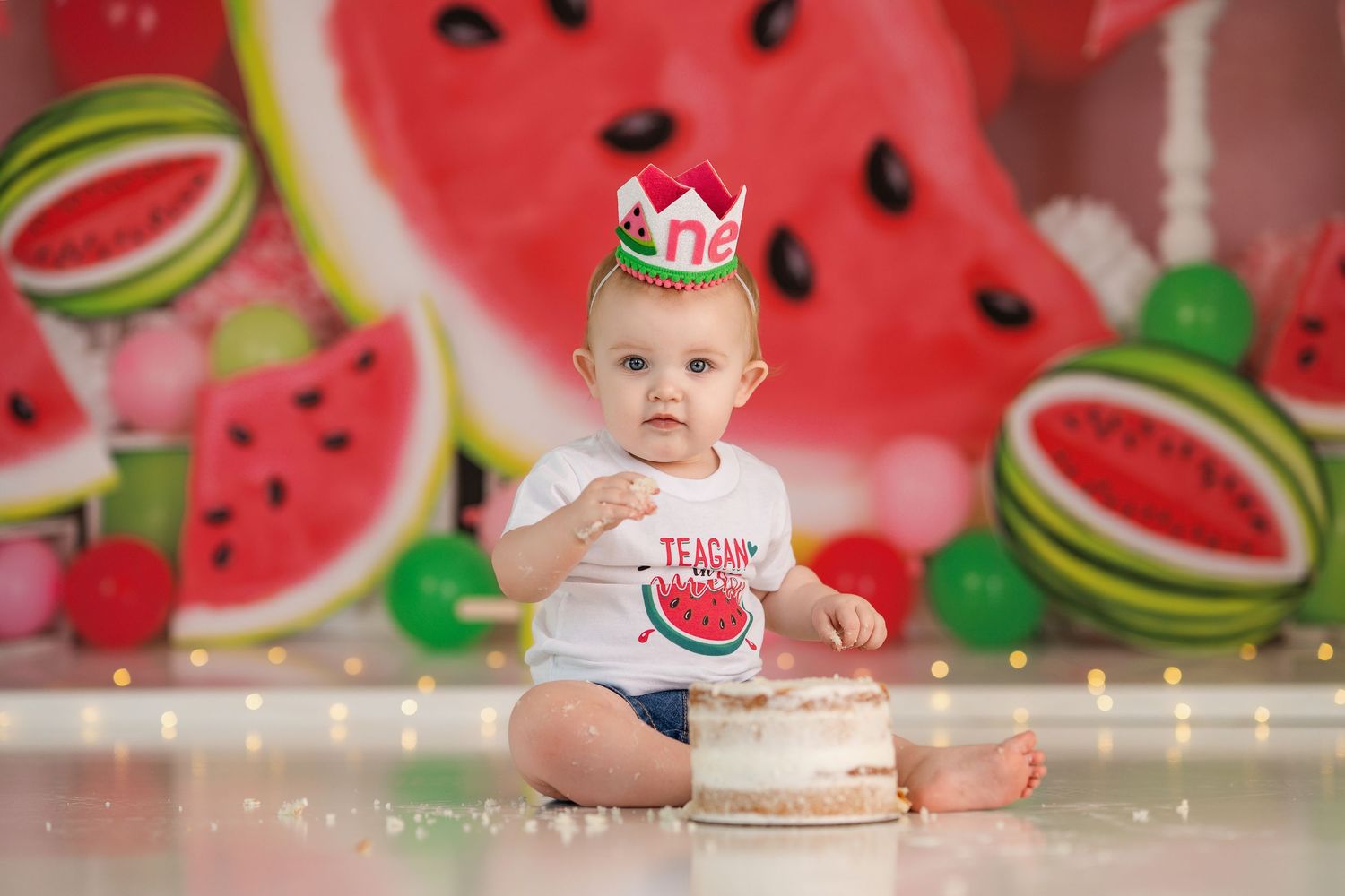Charming photo setup with watermelon backdrop and small decorative crown.