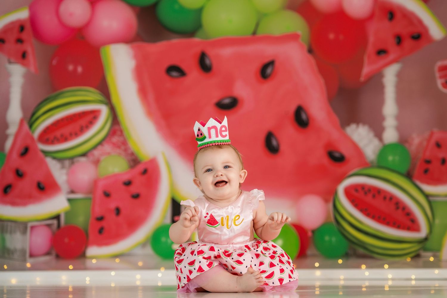 Festive scene with watermelon backdrop and decorative crown against pink background.