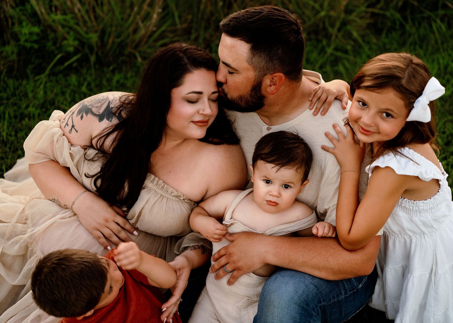 Intimate outdoor family photoshoot at sunset with warm golden lighting.