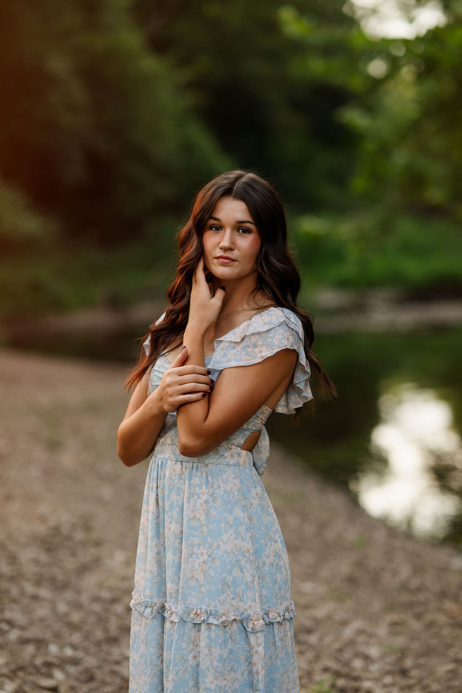 Outdoor portrait session in a light blue floral dress by the water.