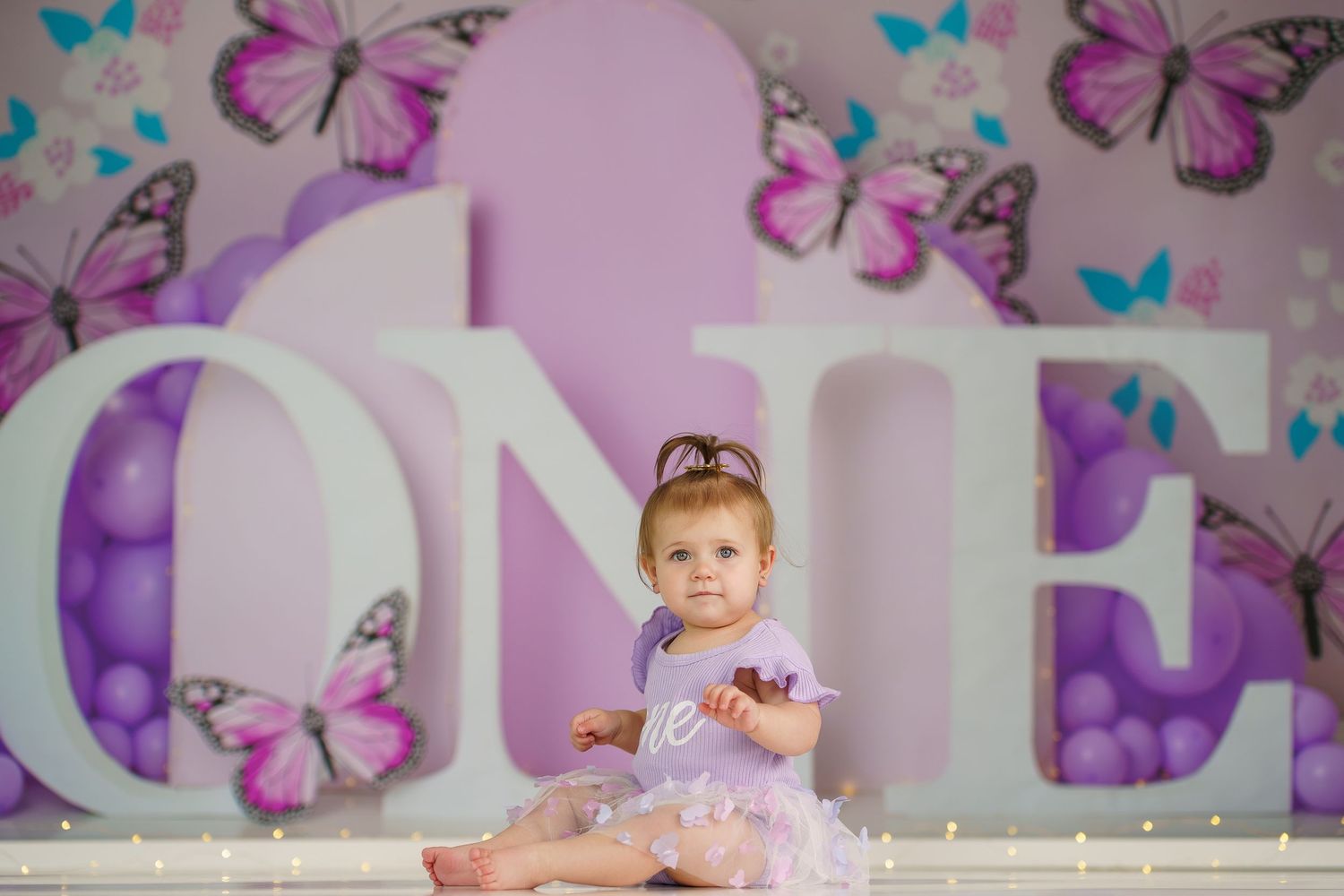 Whimsical purple backdrop with floating butterflies and decorative elements.