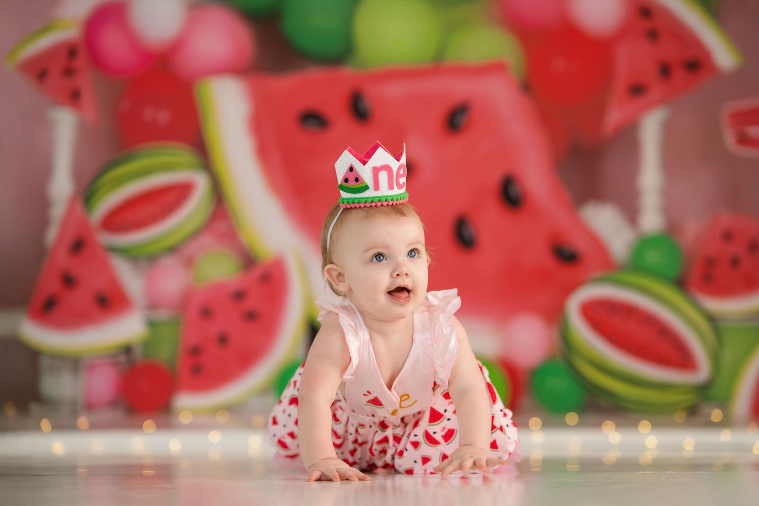 Cheerful scene with watermelon-themed backdrop and decorative crown.