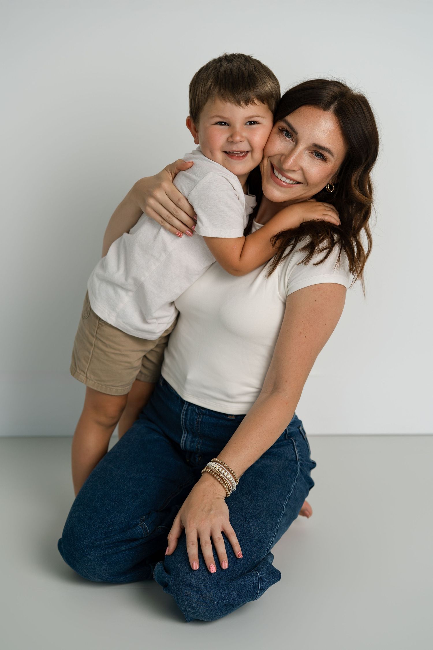 Joyful family photography session with white background and casual styling.