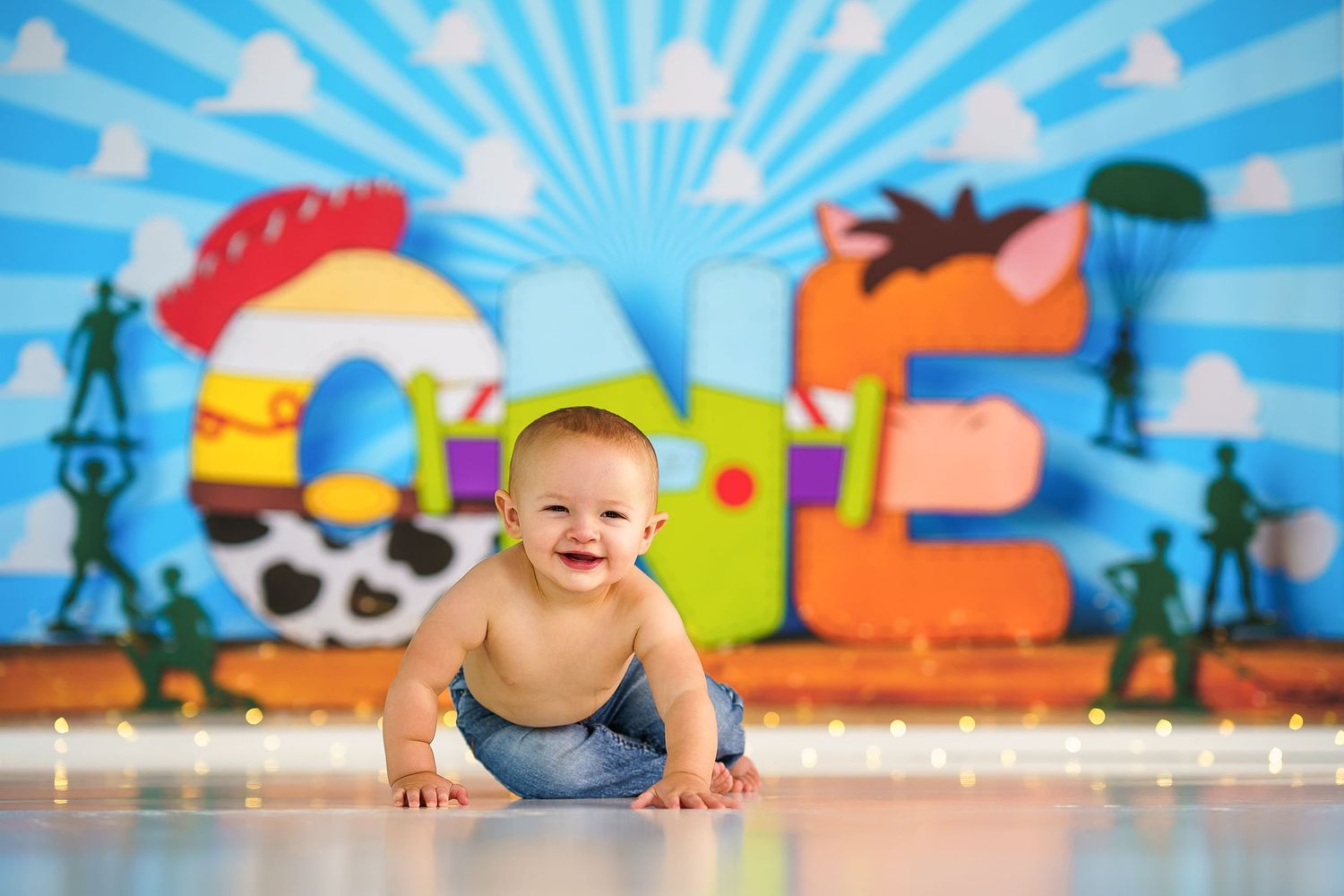 Baby crawling on floor against bright blue background with cartoon pirate decorations.