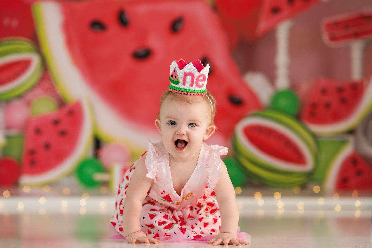 Bright watermelon-themed photo setup with decorative crown and pink outfit.