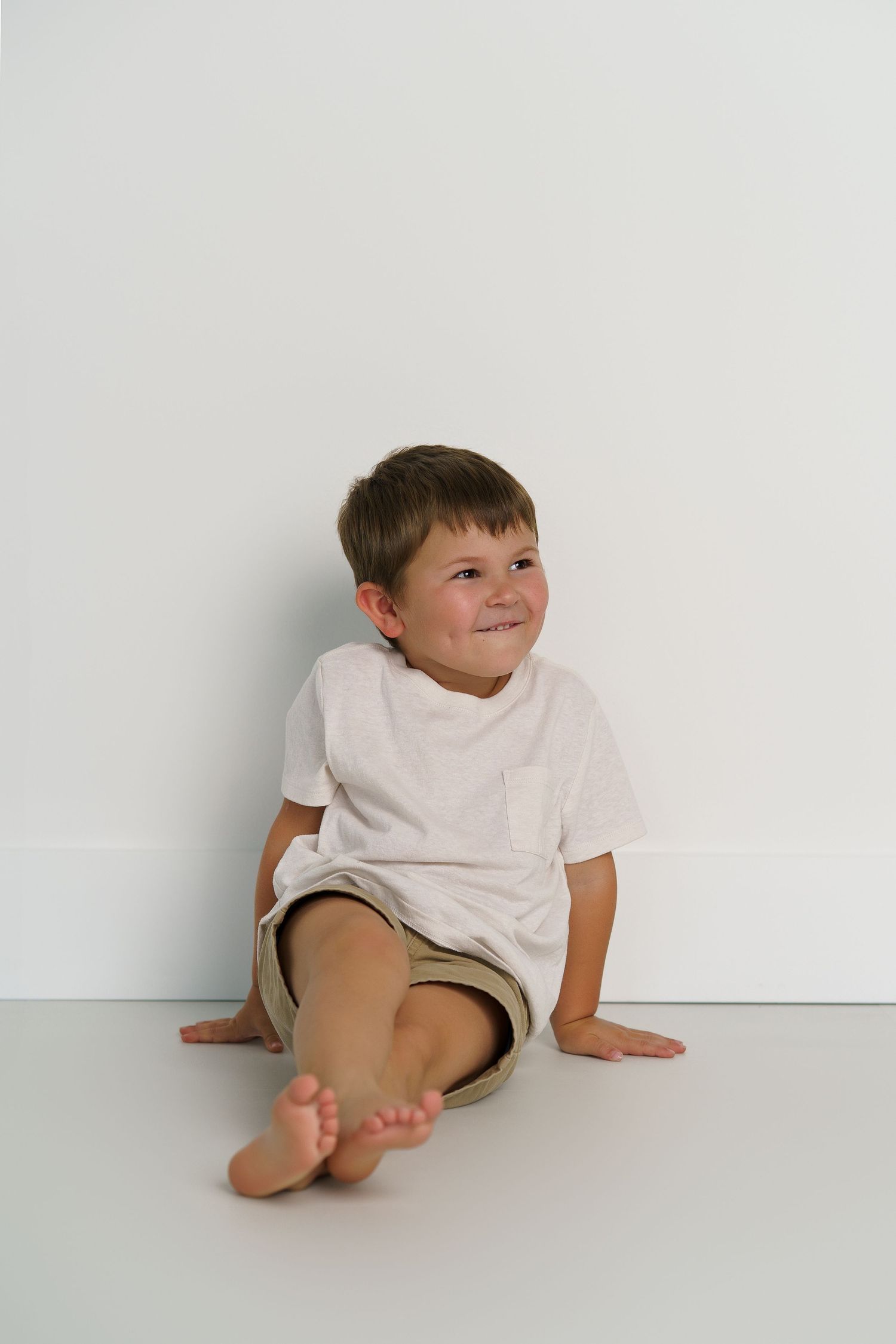Playful child portrait session against clean white background.