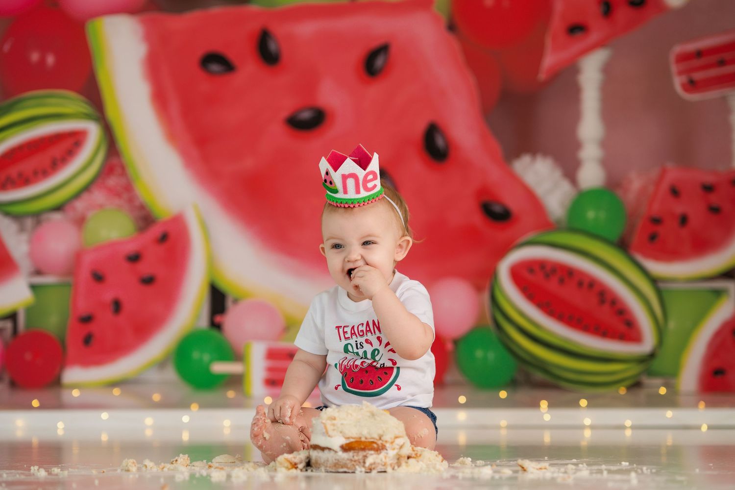 Sweet celebration scene with watermelon backdrop and tiny crown decoration.