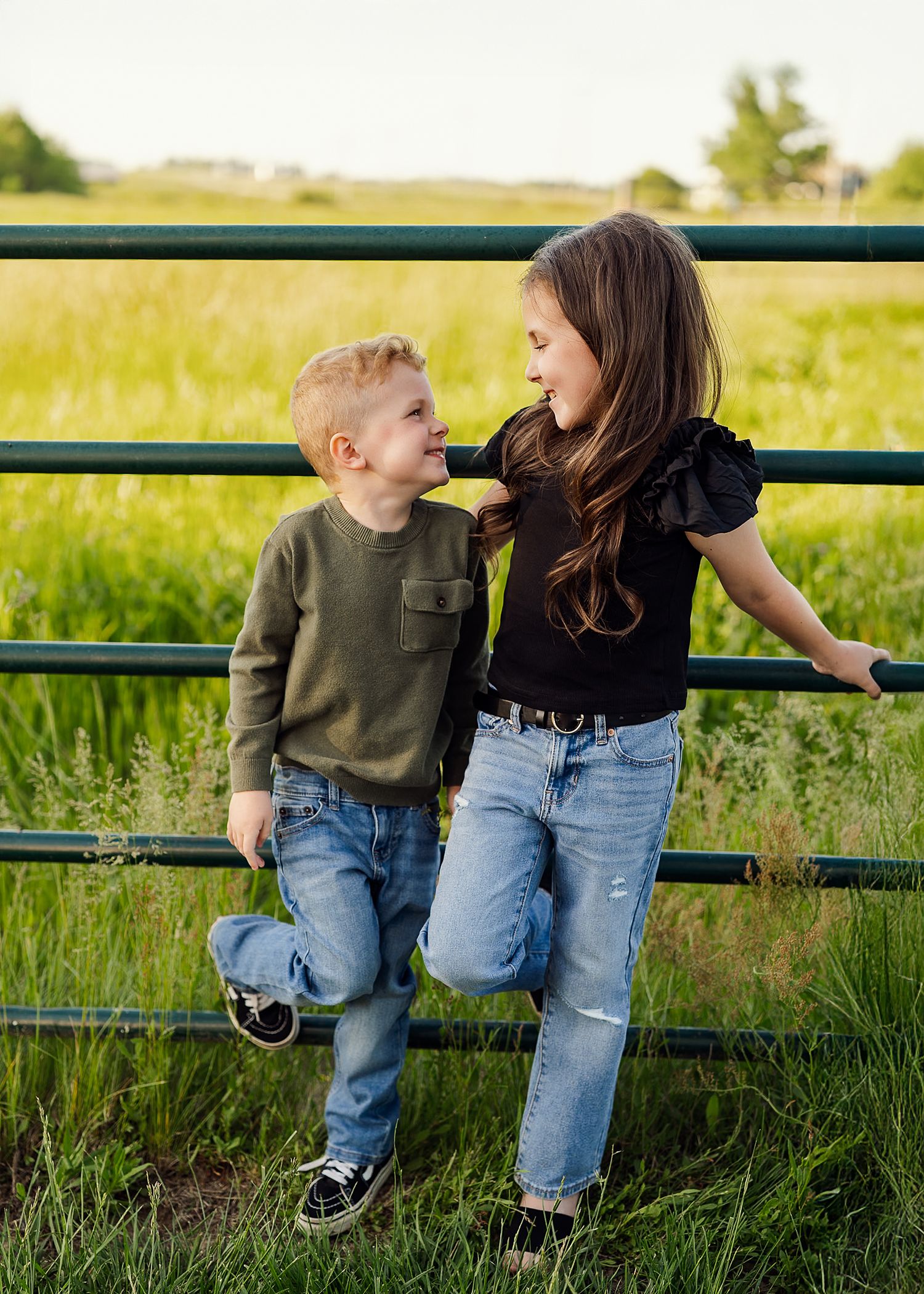 Candid family interaction on green bench surrounded by summer meadow.