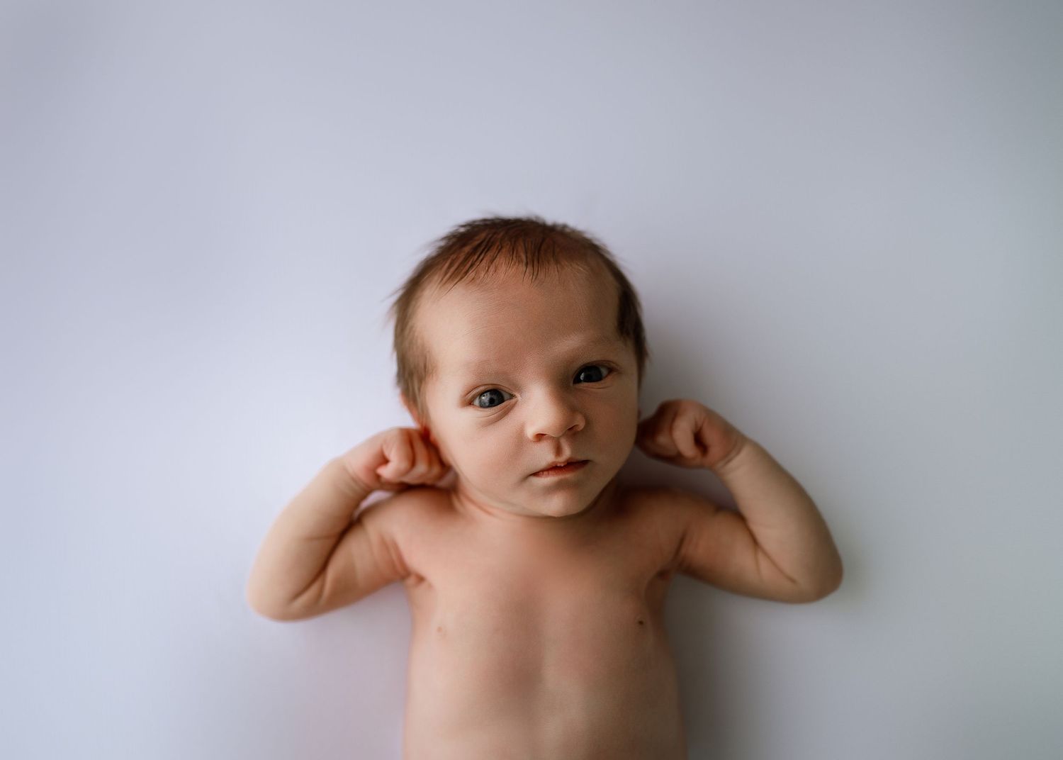 Minimalist baby portrait series against white background showing different poses.