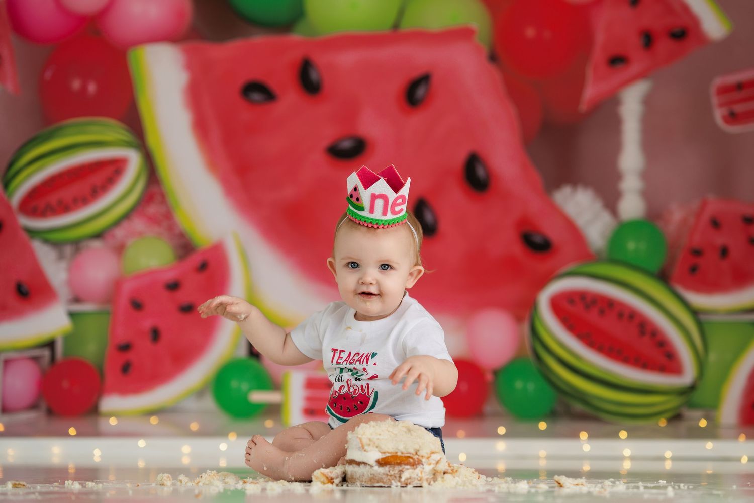 Cheerful watermelon party backdrop with pink and green accents and sparkling lights.