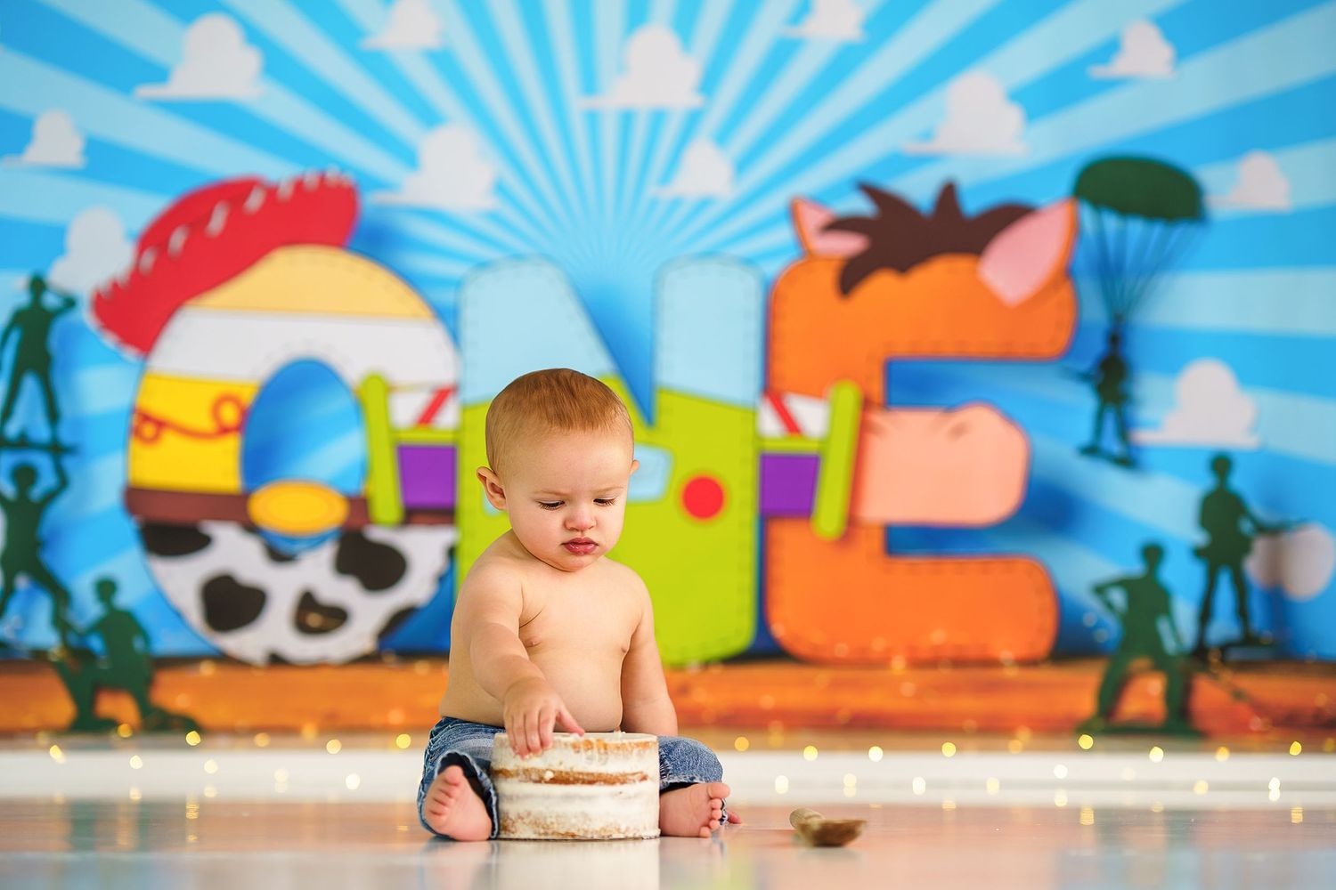 Baby sitting on wooden surface against vibrant blue cartoon background with sunburst design.