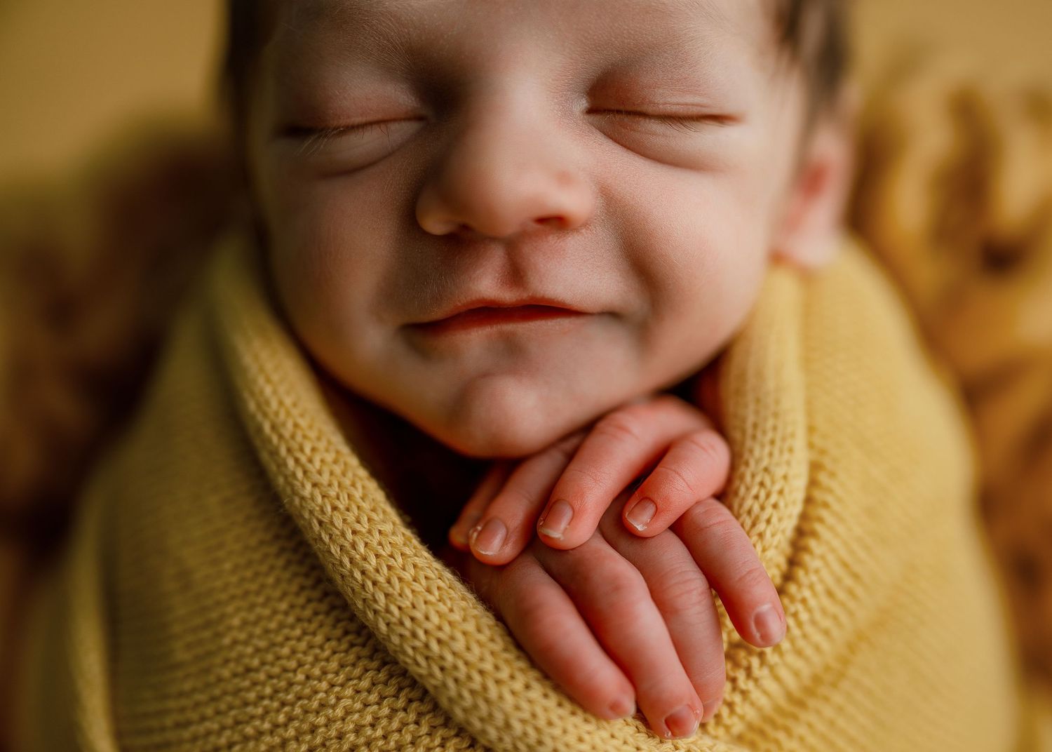 Close-up series of newborn details wrapped in yellow knit against warm background.