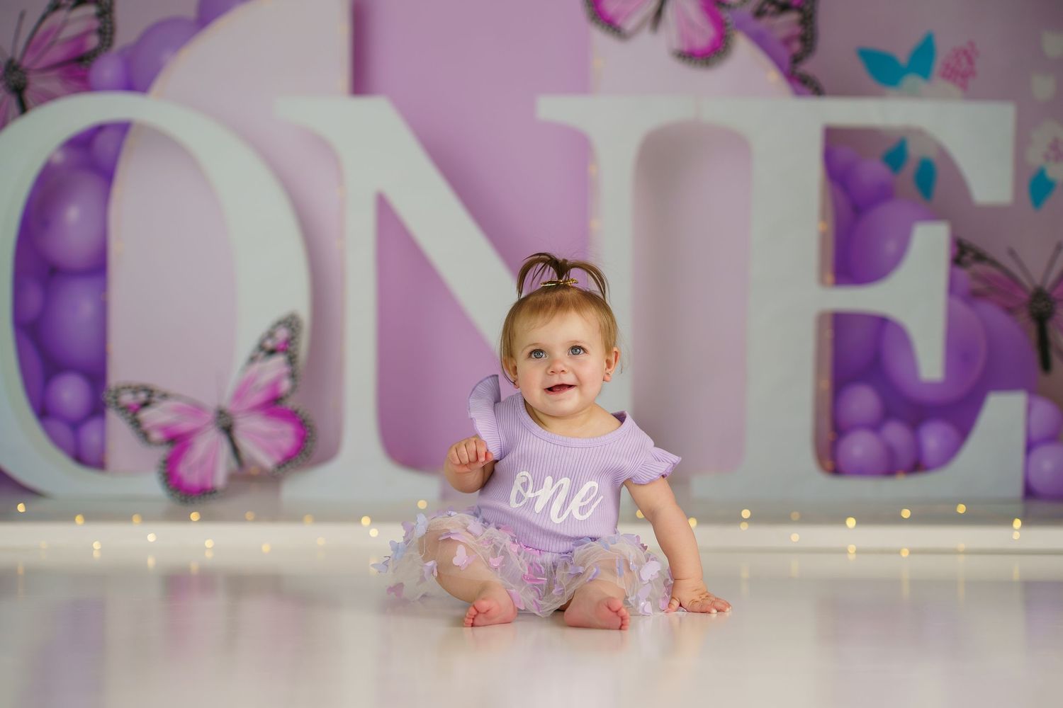 Purple themed room with butterfly decorations and string lights.