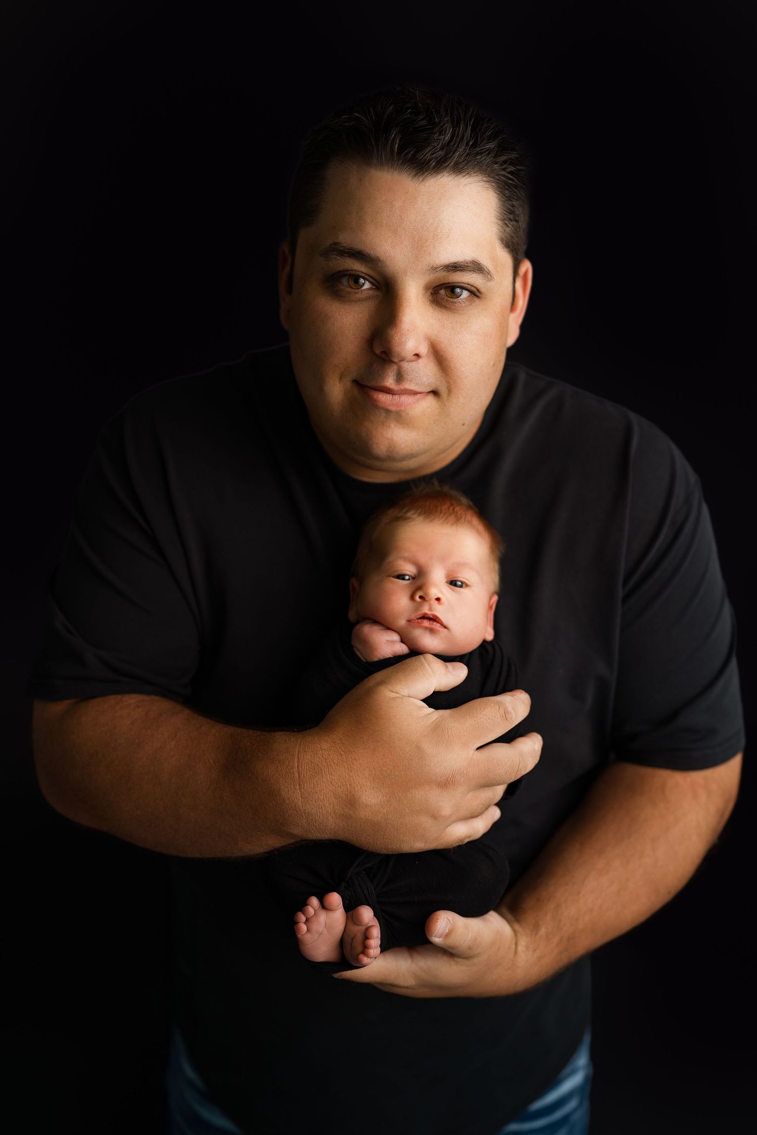 Professional studio portrait session featuring tender parent and newborn moment.