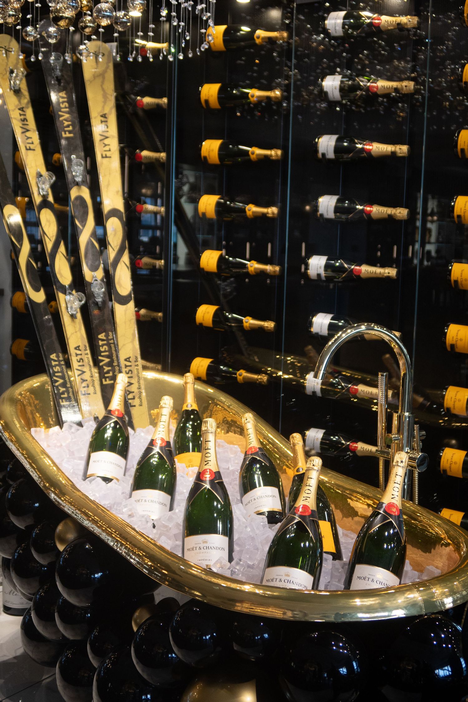 Luxury champagne bottles displayed on ice in an elegant bar setting.
