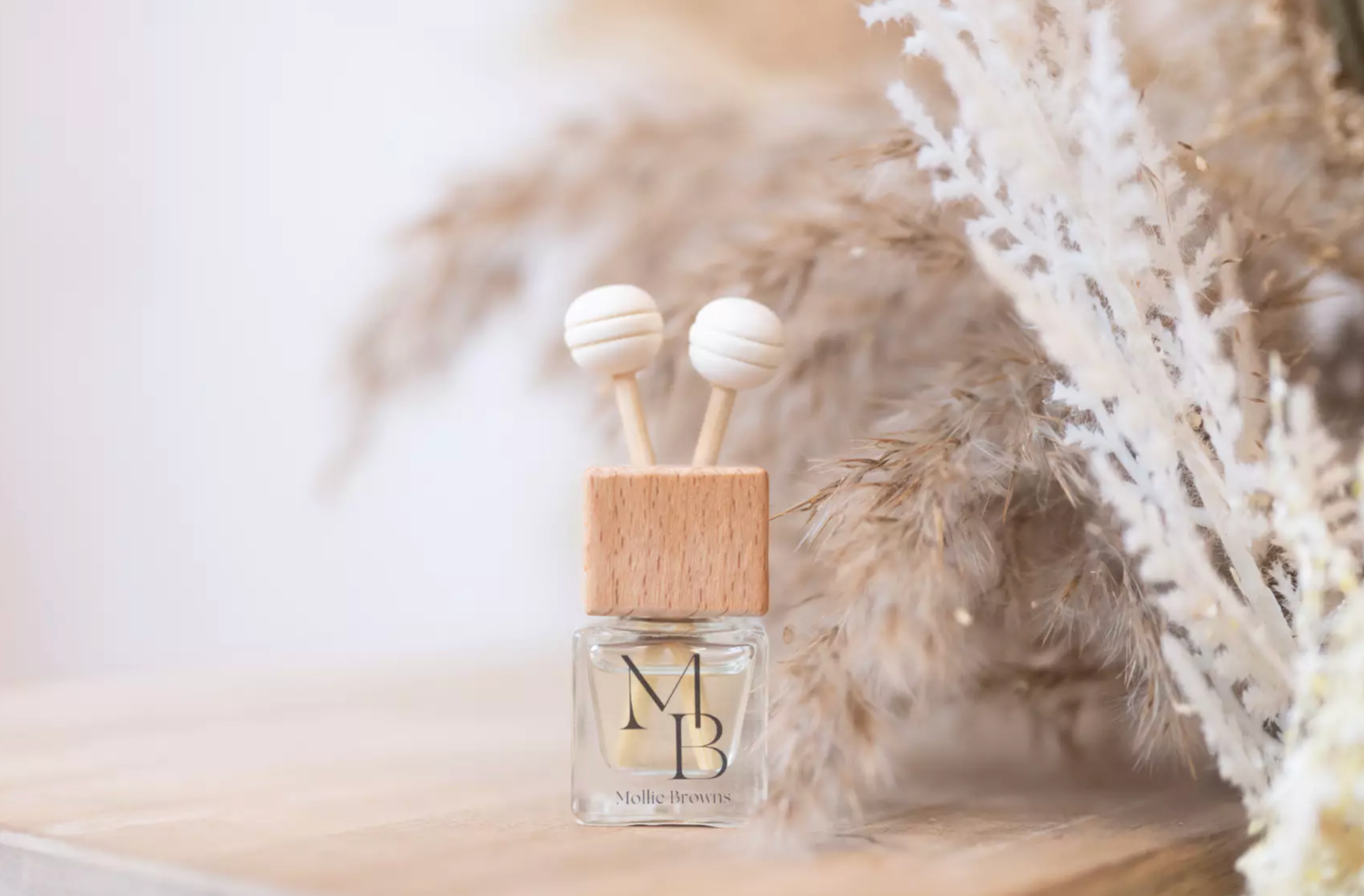 Minimalist product photography setup with dried pampas grass and neutral tones.