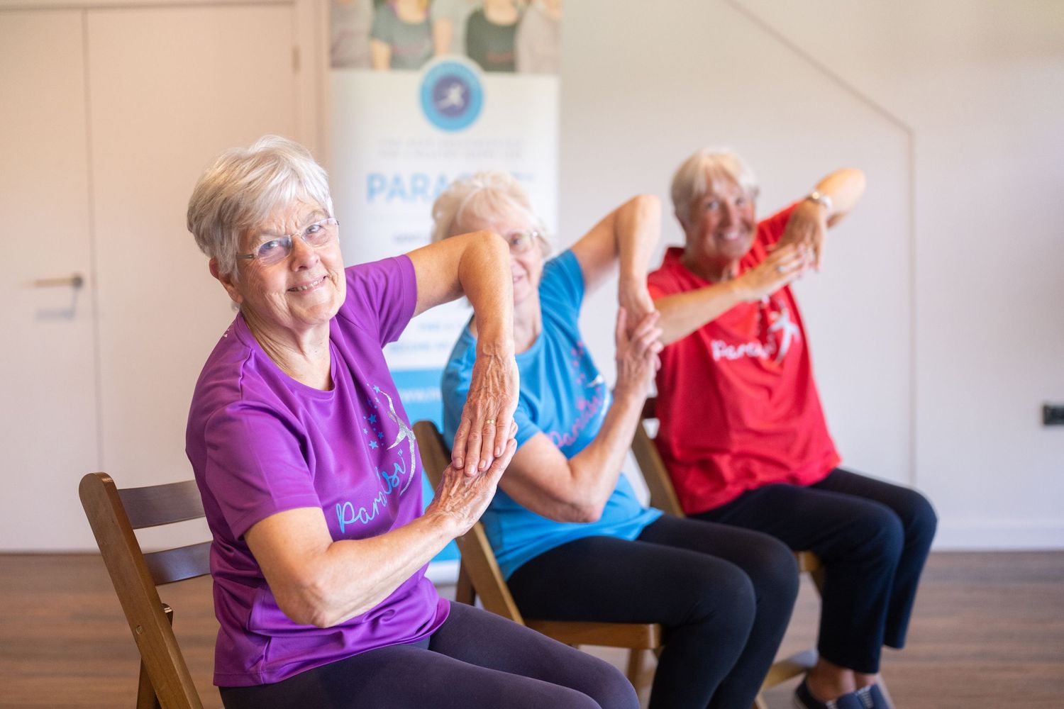 Senior exercise class participants seated in chairs during group fitness session.
