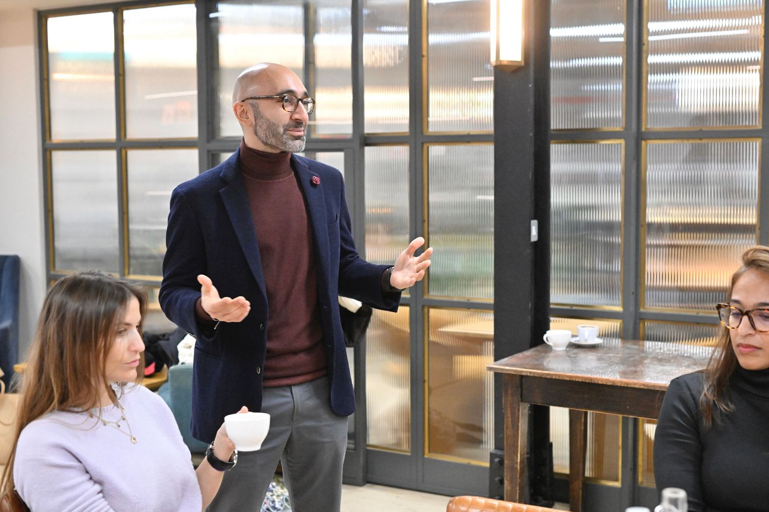 Professional meeting in modern office with glass walls and business casual attendees.