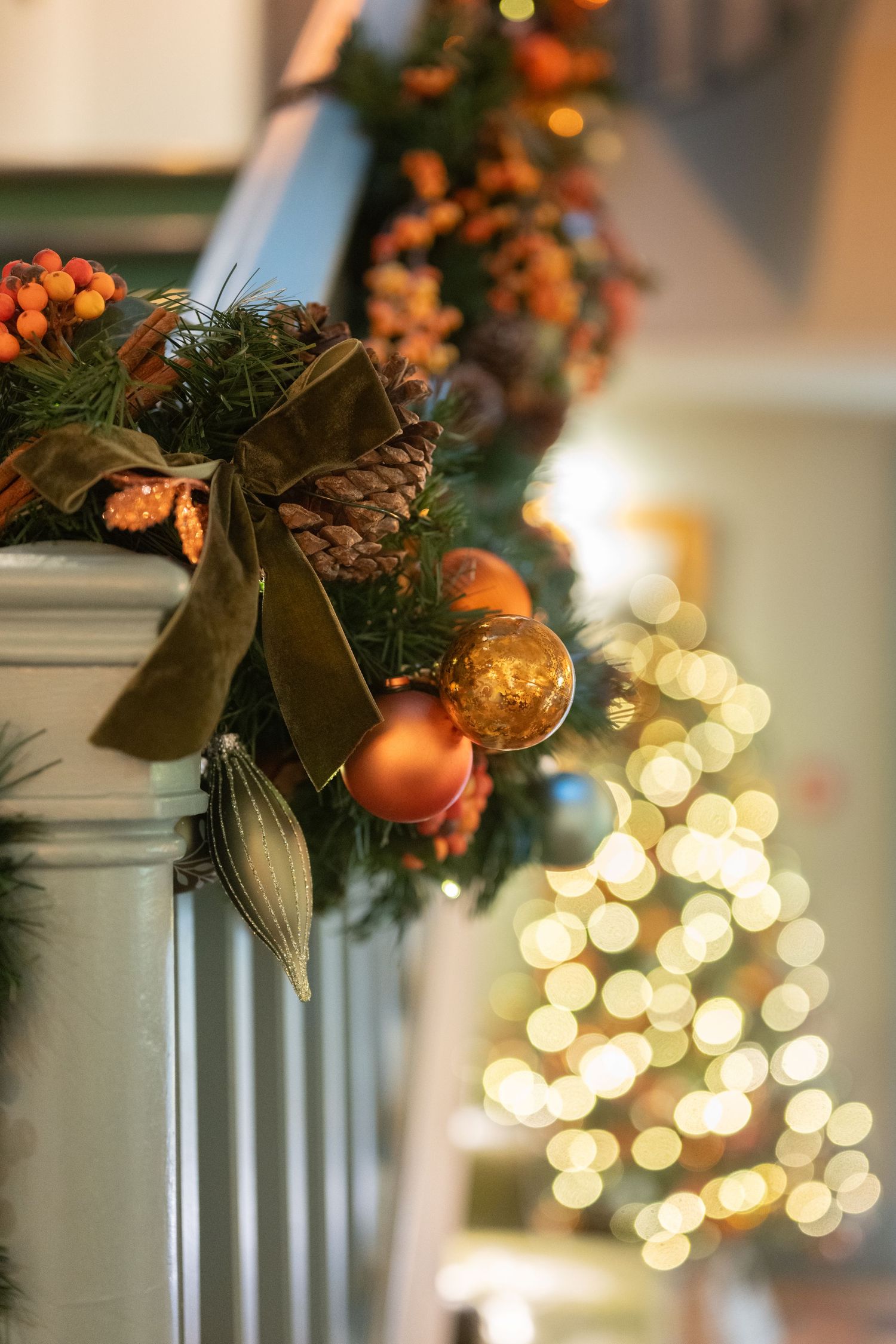 Christmas decorations and twinkling lights create a festive ambiance along a white railing.