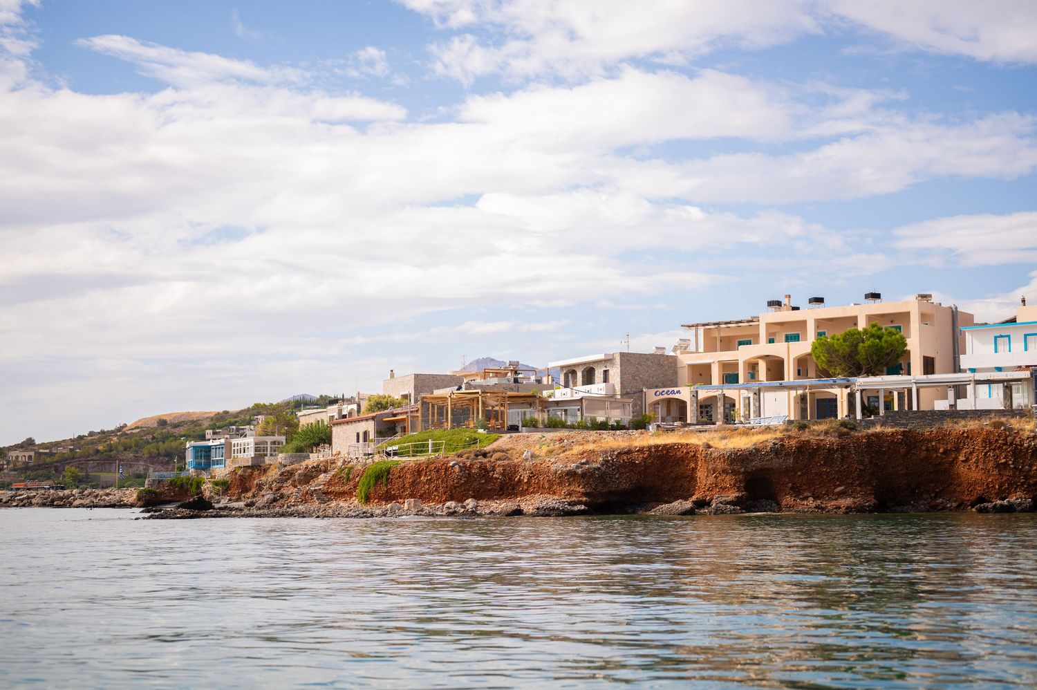 Panoramic view of coastal homes along a rocky Mediterranean shoreline.