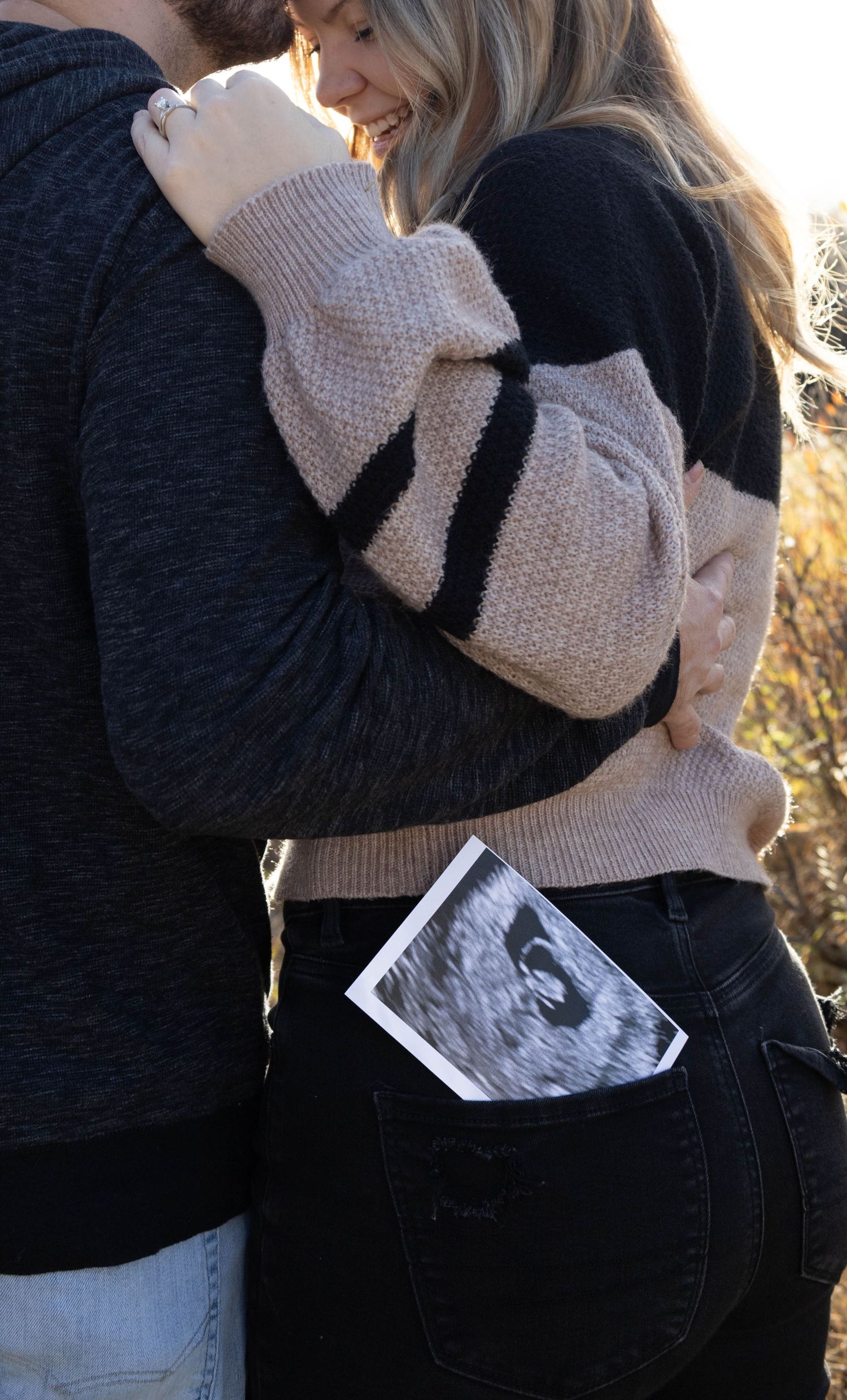 pregnancy photoshoot with ultrasound photo in jean pocket