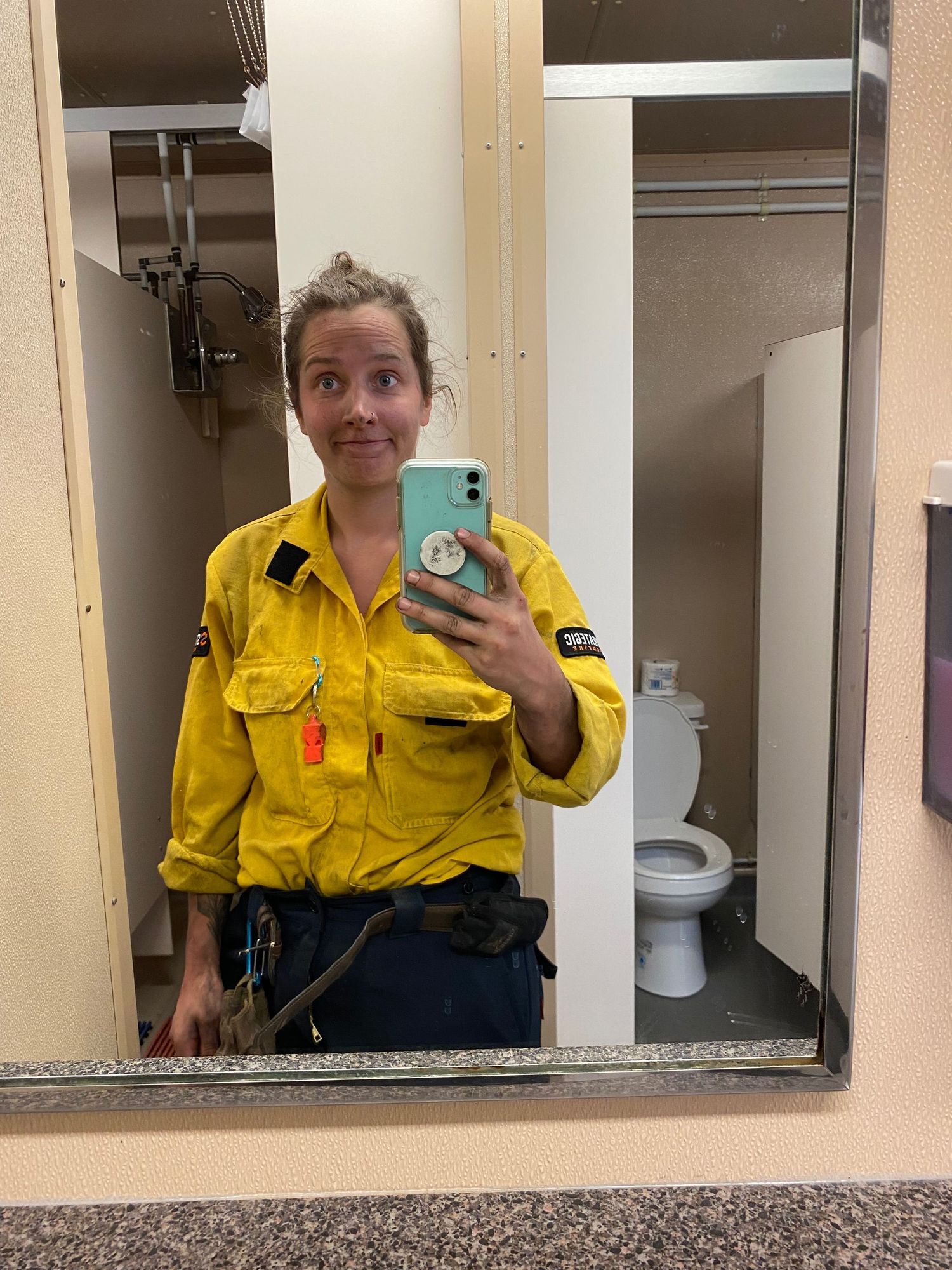 Three mirror selfies show someone wearing a yellow safety uniform and dark pants in what appears to be a restroom.
