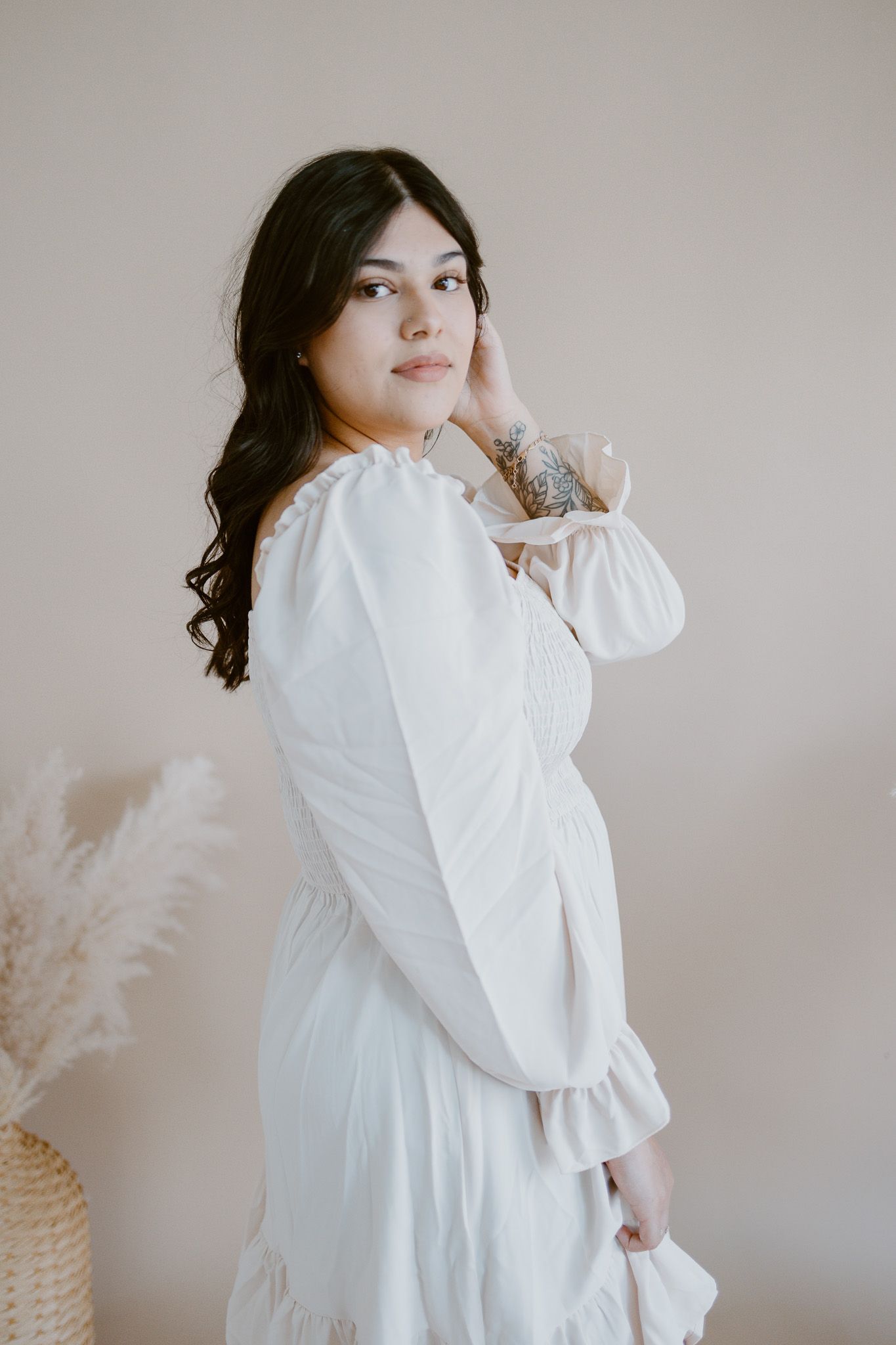 Ethereal portrait session featuring white dress and neutral backdrop with dried florals.