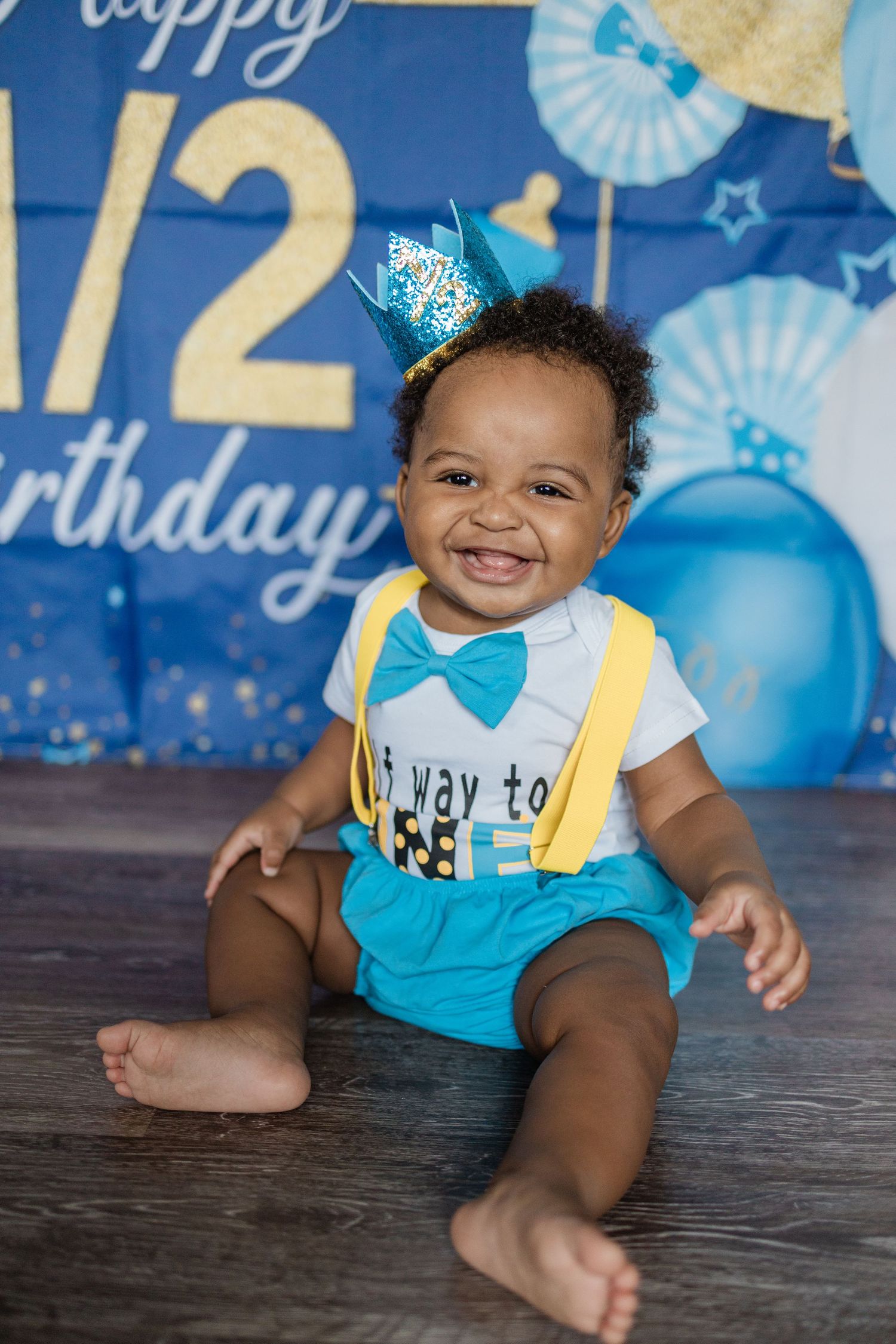 Birthday photoshoot with blue and yellow balloons and festive number decorations.