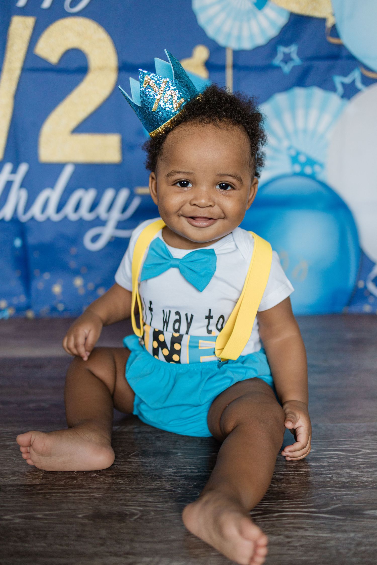 First birthday celebration with blue and gold number backdrop and festive decorations.