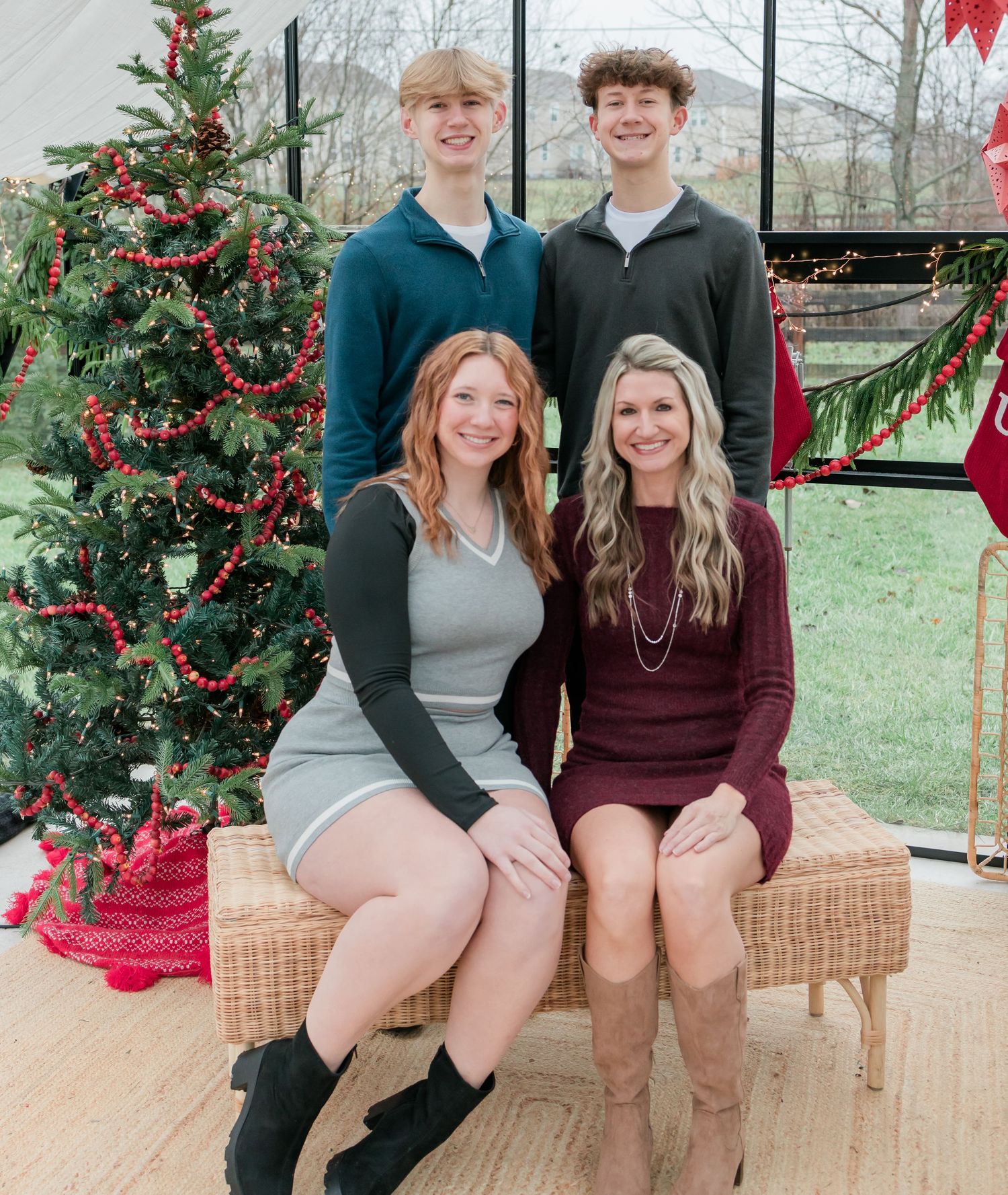 Group holiday photo session with matching outfits in front of decorated Christmas tree.