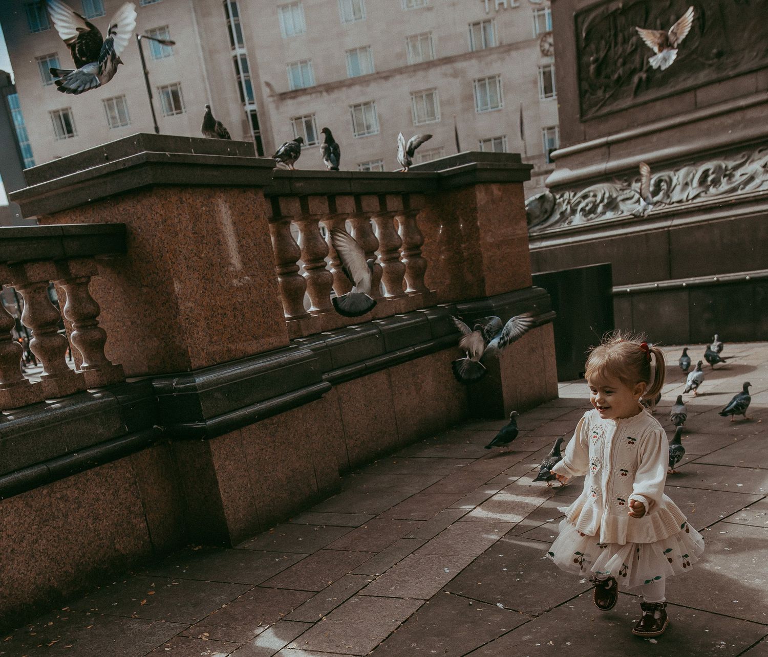 Young child chasing pigeons in Leeds