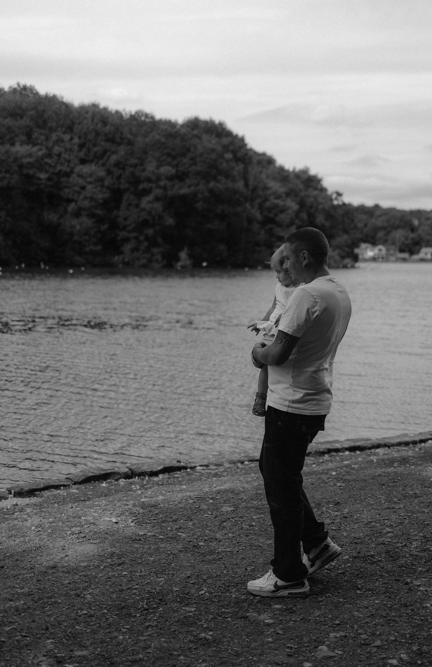 Father holding child and looking out across water