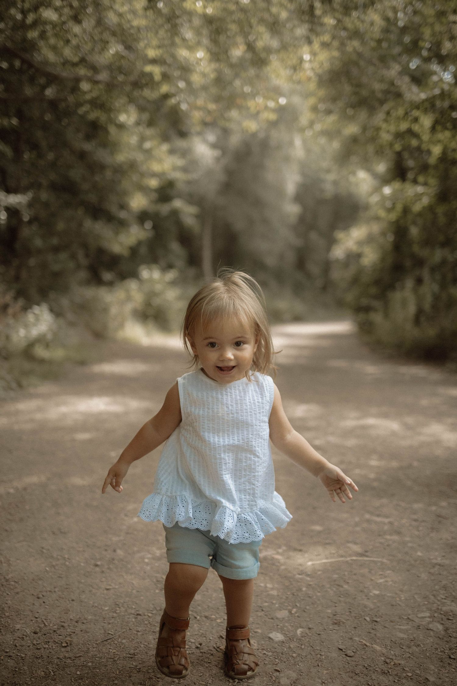 Young child walking across path in countryside